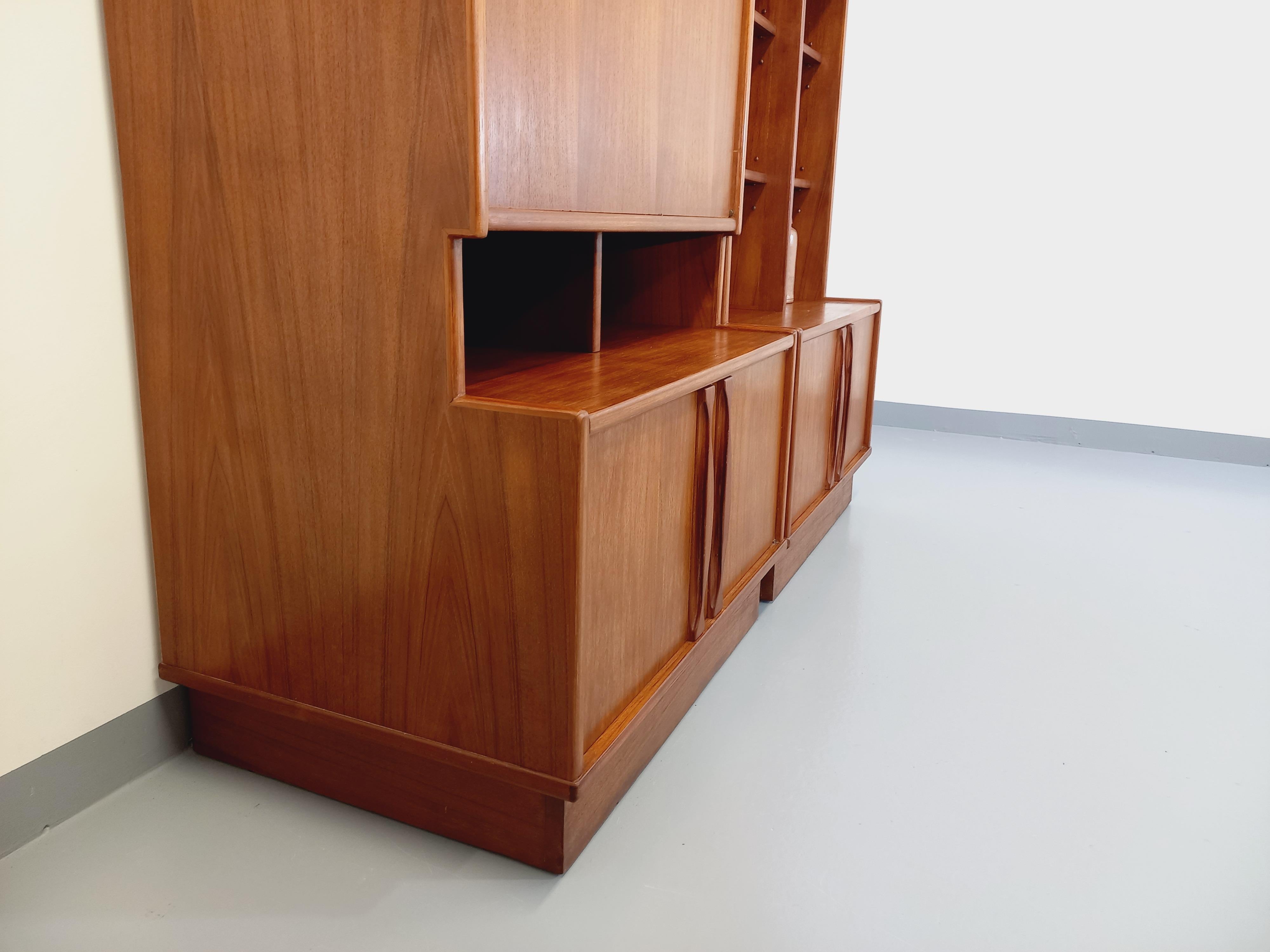 Grande bibliothèque vintage scandinave des années 60, en 2 parties sur plinthes, très beau design scandinave dans le goût de Johannes Andersen, en teck, magnifiques poignées, multiples niches ouvertes, 2 parties 2 portes, 1 partie avec porte