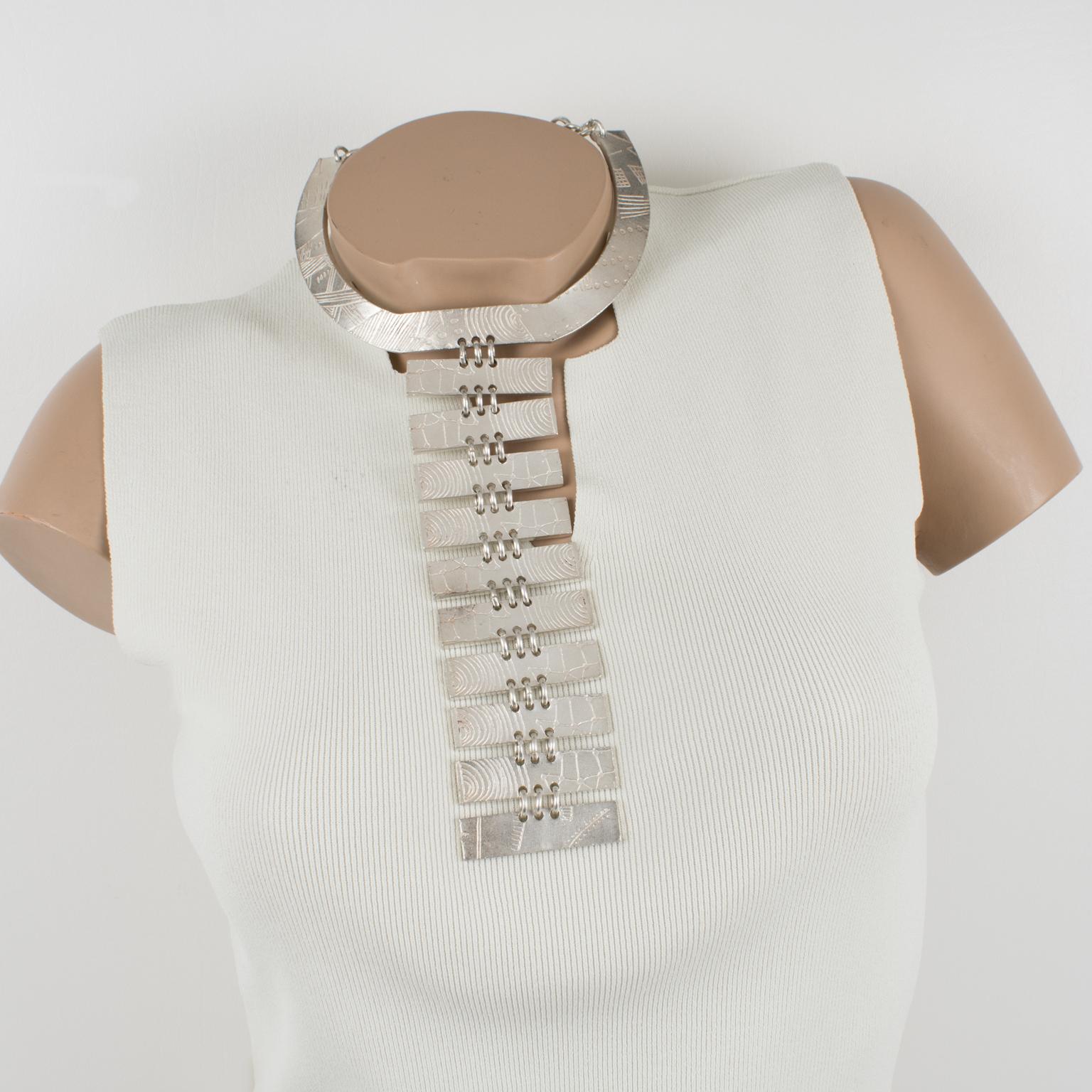 Nelly Biche de Bere Paris a conçu cet impressionnant collier plastron futuriste en métal argenté. Le rare collier à pendentifs présente une forme de cravate massive et surdimensionnée avec un motif de graffiti. Le design complexe présente des lignes