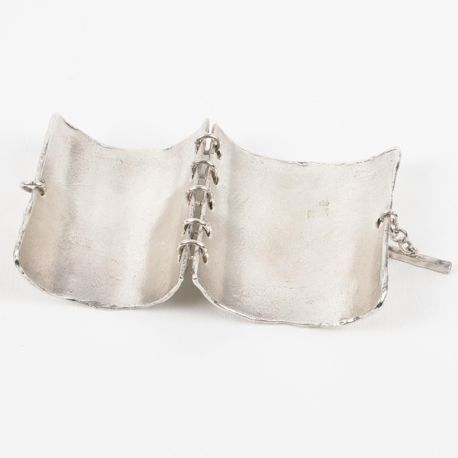 Nelly Biche de Bere, Paris, designed this massive modernist silver plate link bracelet. It features a chunky oversized bangle with a brutalist carved and hand-made feel design ornate with a textured pattern. The two elements are slightly curved to