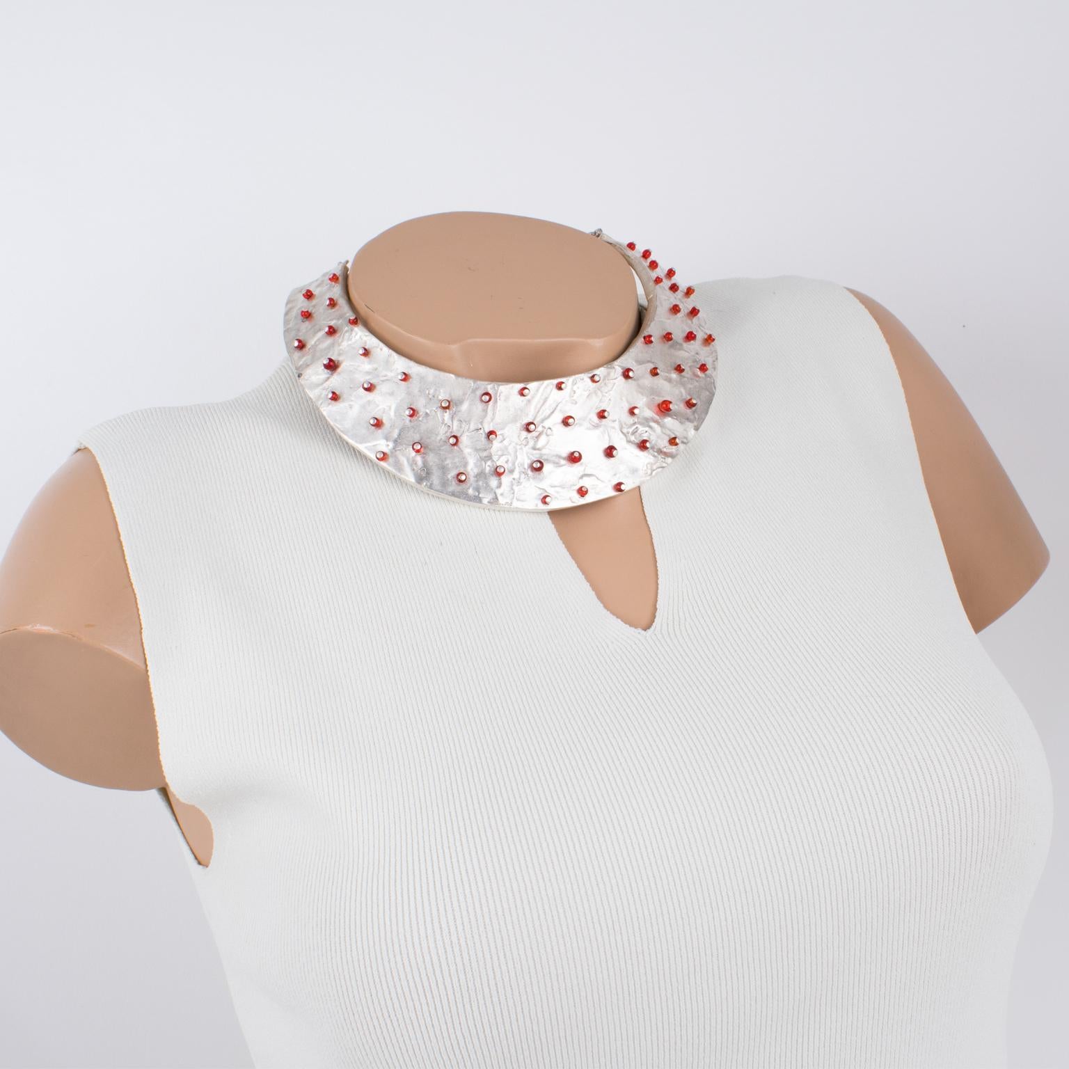 Nelly Biche de Bere, Paris, designed this stunning modernist silver plate rigid collar necklace in the 1990s. The chunky, massive shape features a brutalist, carved, and hand-made feel, topped with randomly displayed tiny ruby red glass beads. The
