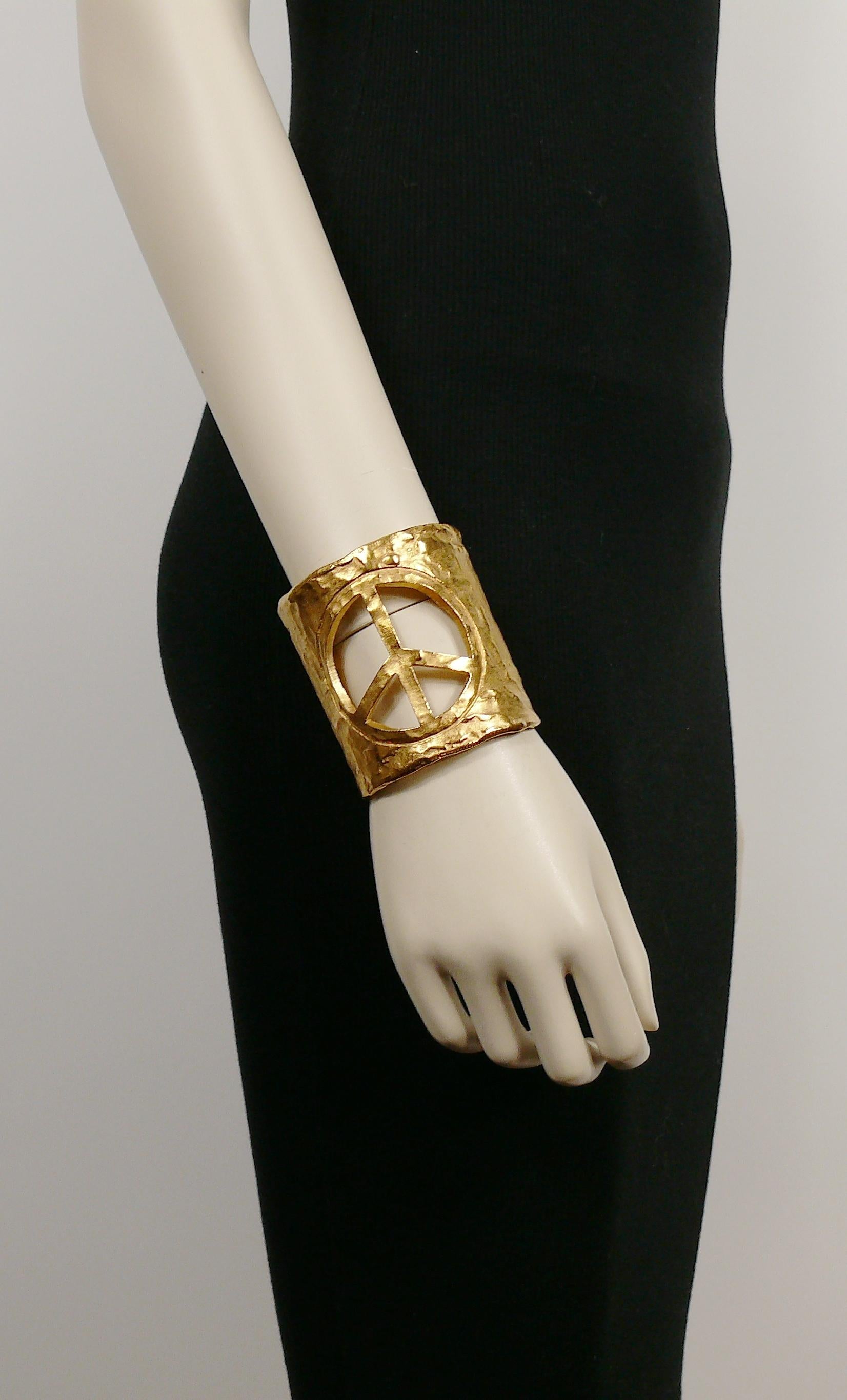 BICHE DE BERE vintage gold toned textured cuff bracelet featuring a cut-out peace sign.

Embossed 48/53.
Unmarked.

Indicative measurements : inner circumference approx. 17.91 cm (7.05 cm) / width approx. 7.1 cm (2.80 inches).

Comes with original