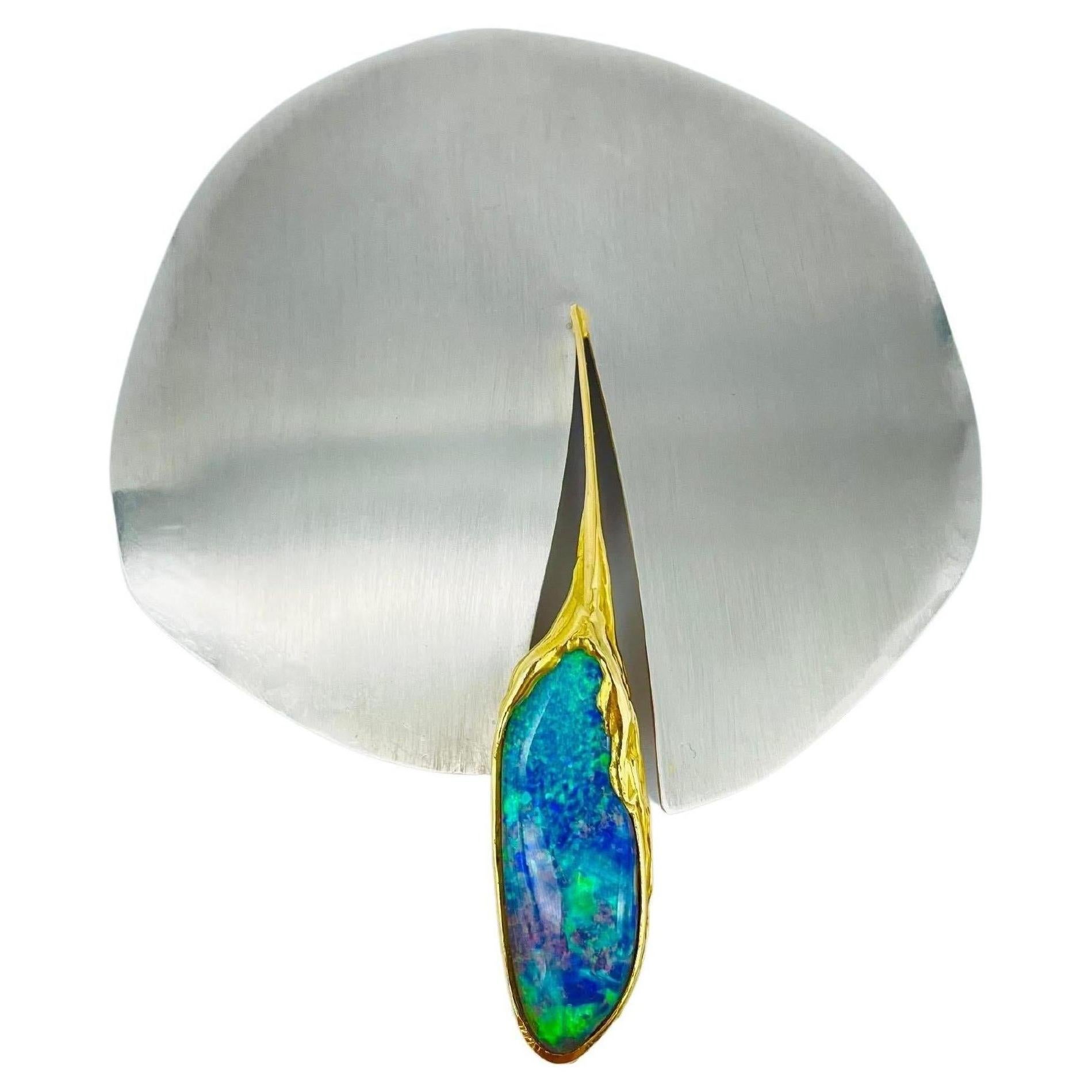 This breathtaking piece of jewelry is a true work of art. Made of exquisite 950 platinum and 18k yellow gold, this unique brooch-pendant is set with a stunning oval Australian opal that radiates a captivating play of colors. The opal is expertly cut
