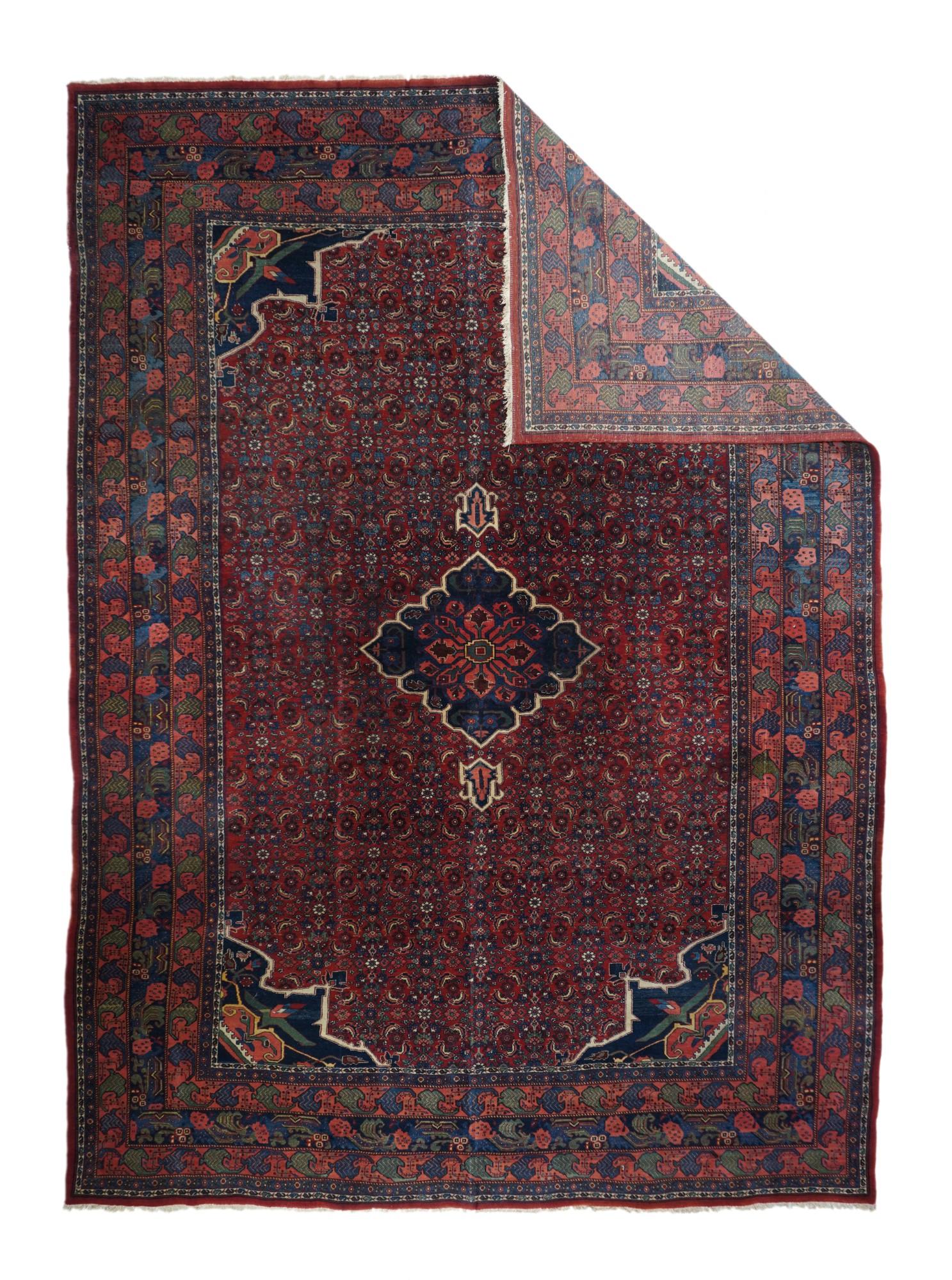 This board-like, compactly woven Kurdish scatter shows a red field covered closely with an allover small Herati design. A cusped and pendanted dark blue medallion floats on top and is matched by the dark blue and cream corners. Triple border set