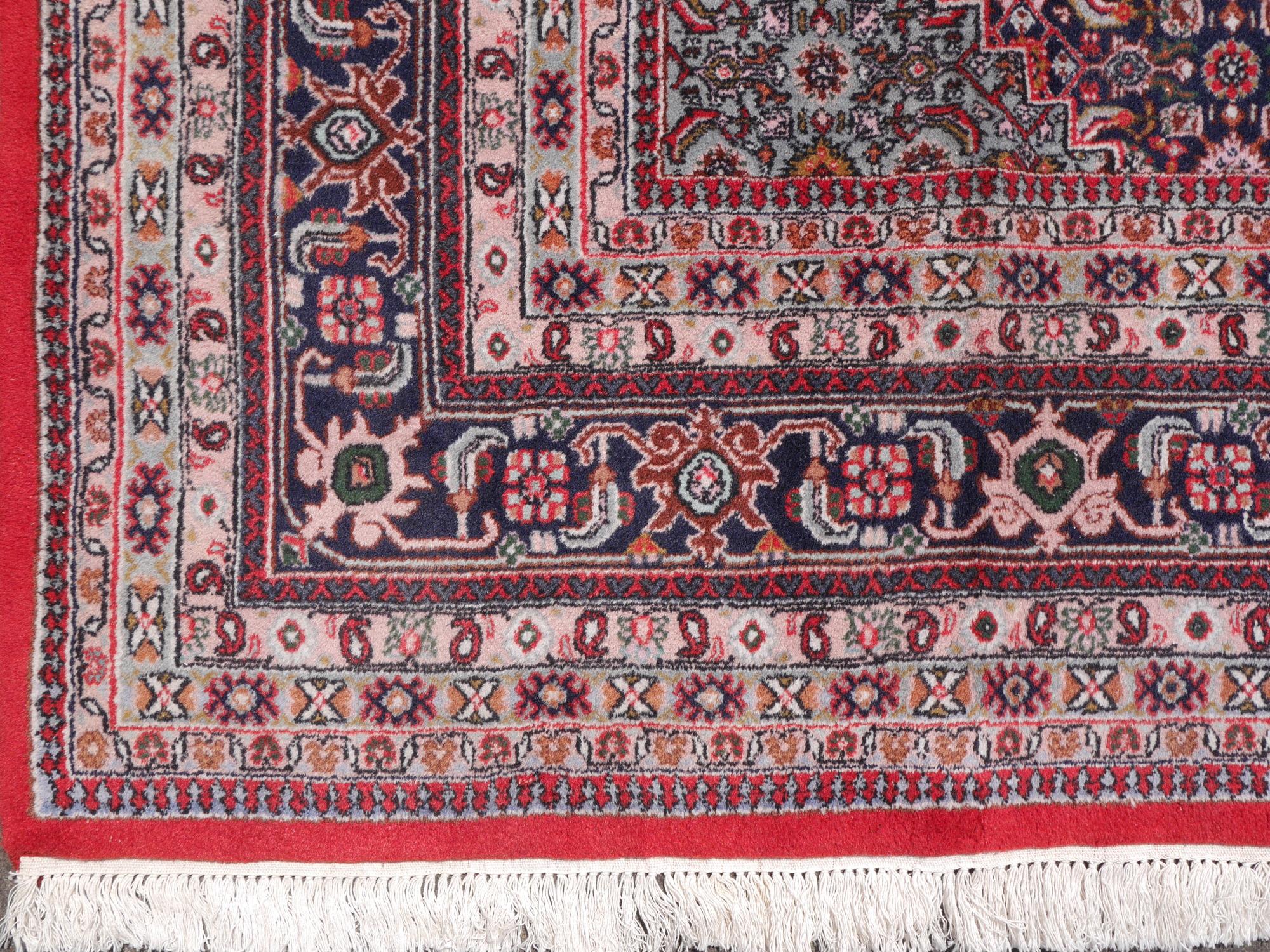 A hand-knotted Oriental rug inred and blue, made in the 1980s. Pile is pure wool, warp and weft is cotton. The rug is in very good condition with vibrant colors.

Pile material: Fine wool, very good pile
Weft material: Cotton
Warp material: