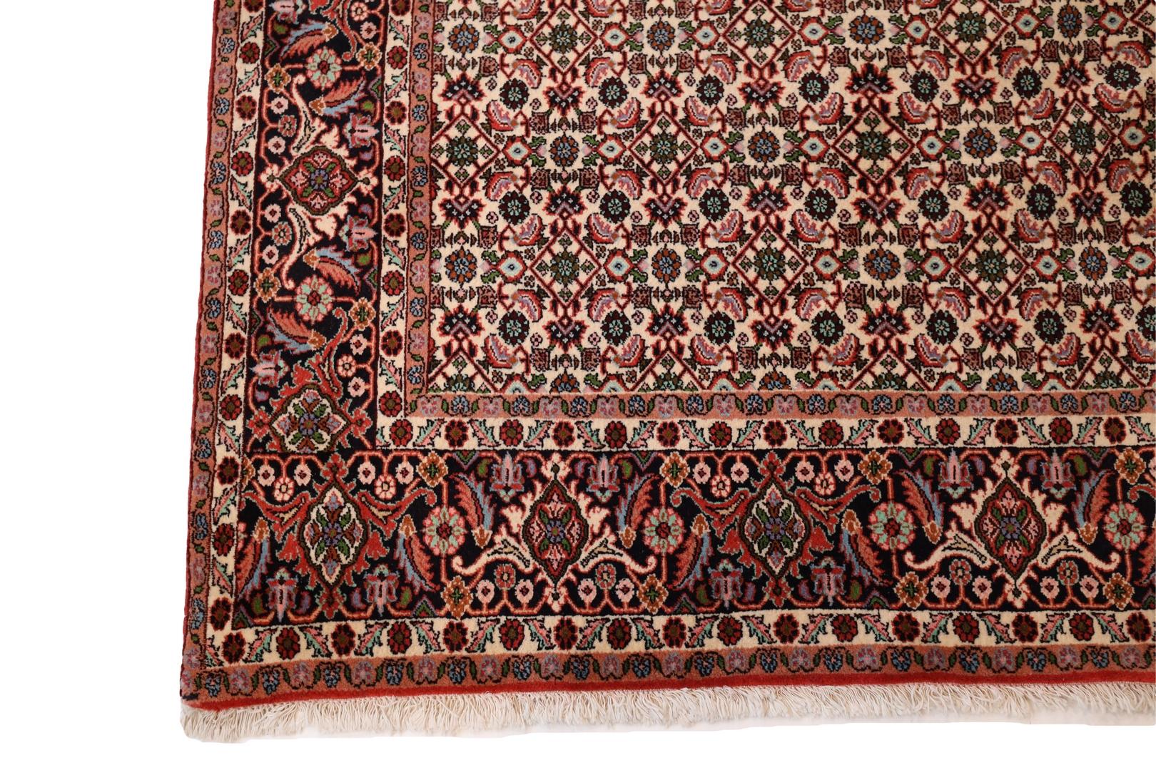 A Bijar rug is a hand-woven Persian rug that comes from the city of Bijar in the western part of Iran. This particular Bijar rug has an ivory background with a beautiful all-over geometric floral design. The design is comprised of thin and tight