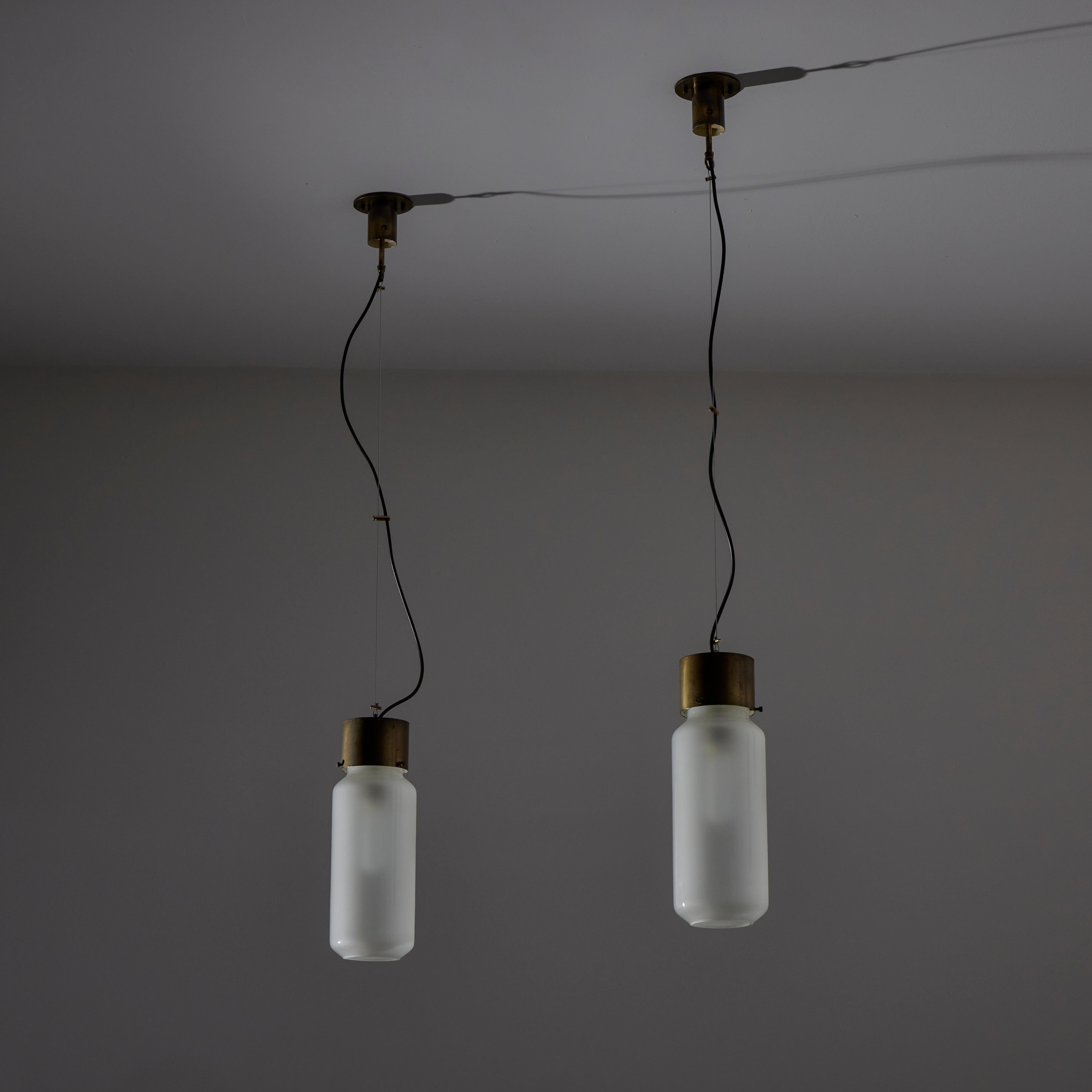 Ciondoli 'Bidone' di Caccia Dominioni per Azucena. Progettato e prodotto in Italia, nel 1958. Vetro acidato cilindrico con baldacchino in ottone e sospensione in cavo d'acciaio. Ogni lampada contiene una lampadina E27, adattata agli Stati Uniti. Si