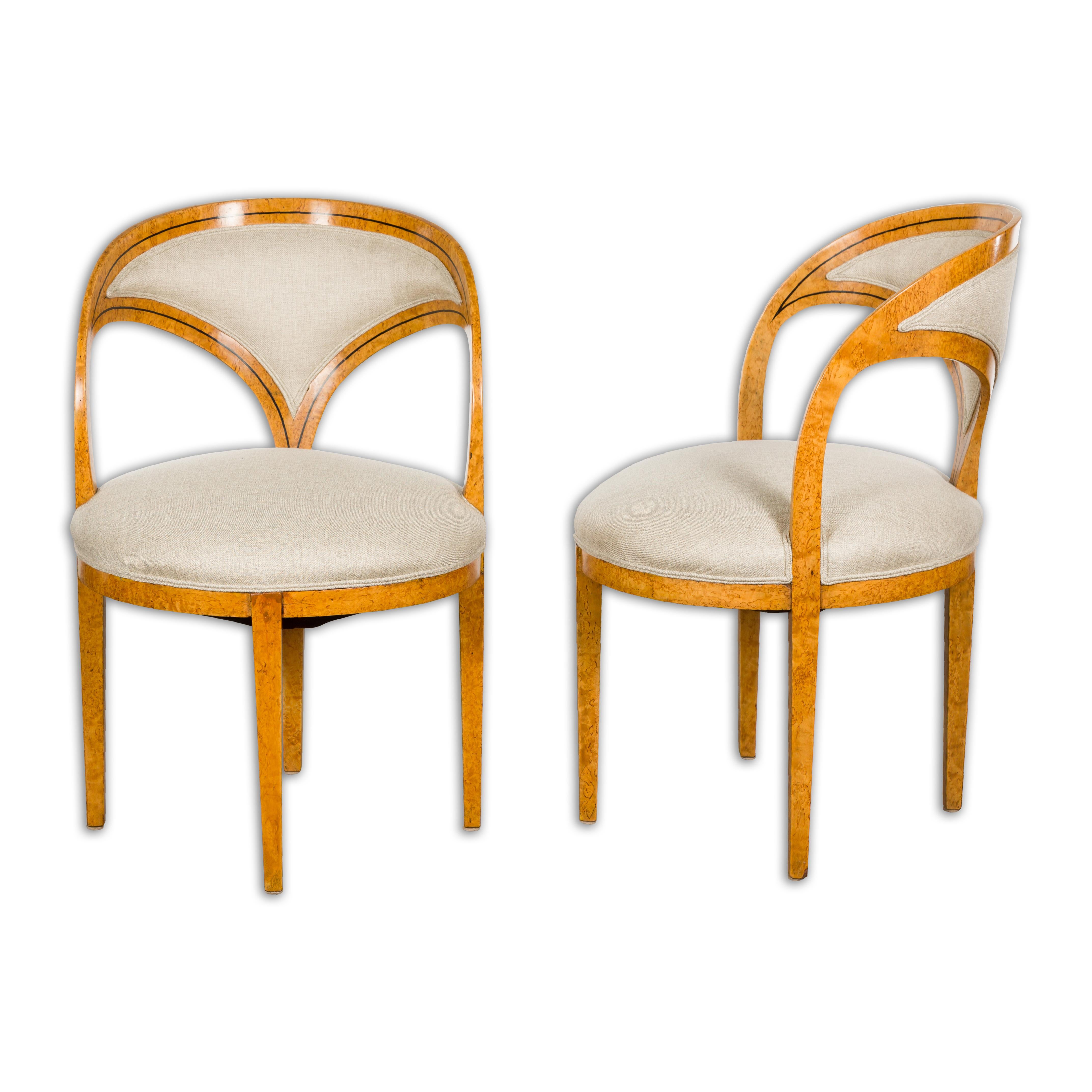 A pair of Biedermeier period Austrian chairs from the 19th century with horseshoe style backs, ebonized banding, four tapering legs and new custom upholstery. This elegant pair of Biedermeier period Austrian chairs, dating from the 19th century,