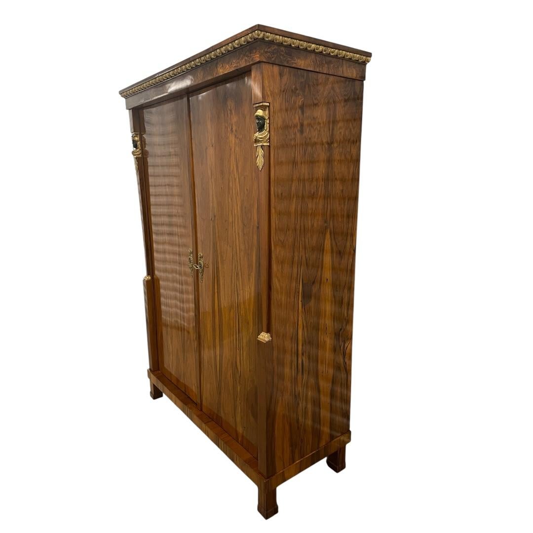Biedermeier Armoire, Austria, circa 1820 – Walnut Veneer with Caryatid Decor
This elegant Biedermeier armoire dates to around 1820 and showcases the refined simplicity and classical influence of early 19th-century Austrian furniture. Crafted with