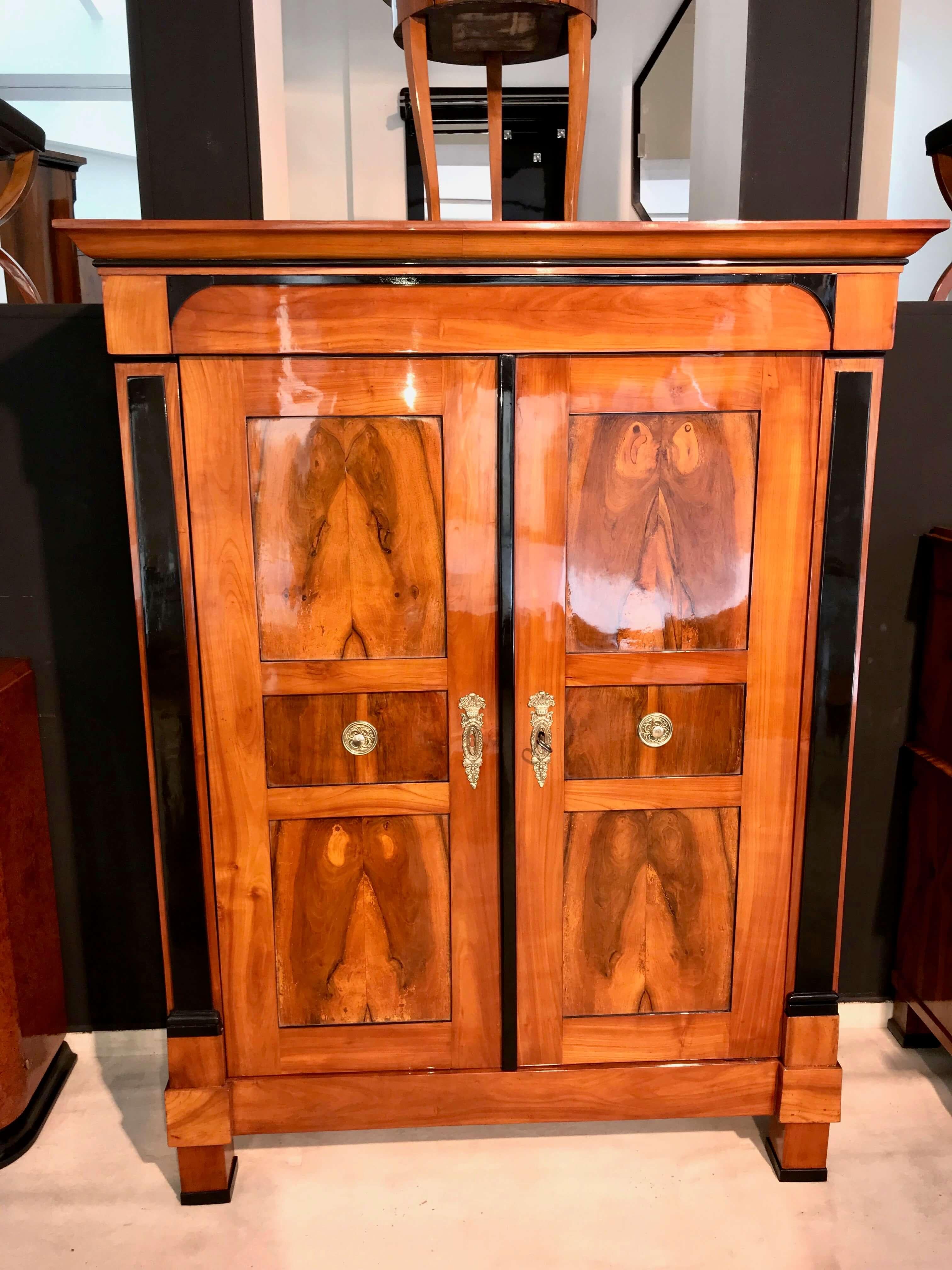 Superb, big Biedermeier Armoire from Southwest Germany near Bodensee, circa 1820

Cherry solid wood frame with walnut inlays at the front and sides.
Wonderful original brass fittings and old box-lock.
Ebonized pilaster-columns. 

Inside: 4