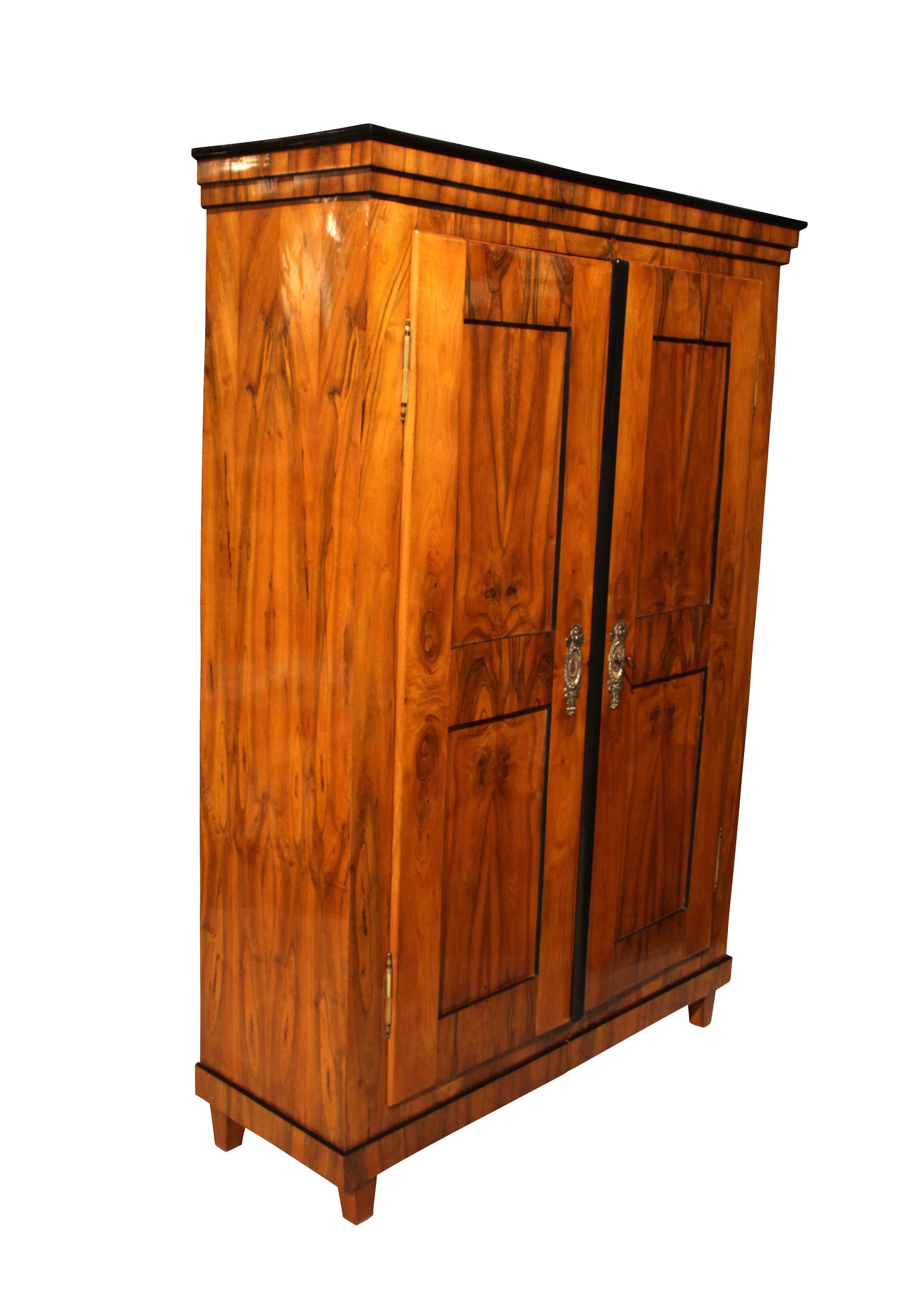Beautiful, well-proportioned, 2-doored Biedermeier Armoire with filling panels.

Provenience: South Germany around 1820.

Wonderful walnut veneer frame and inlays. 
Original brass fittings and original, working, lock and key. 
French-polished with