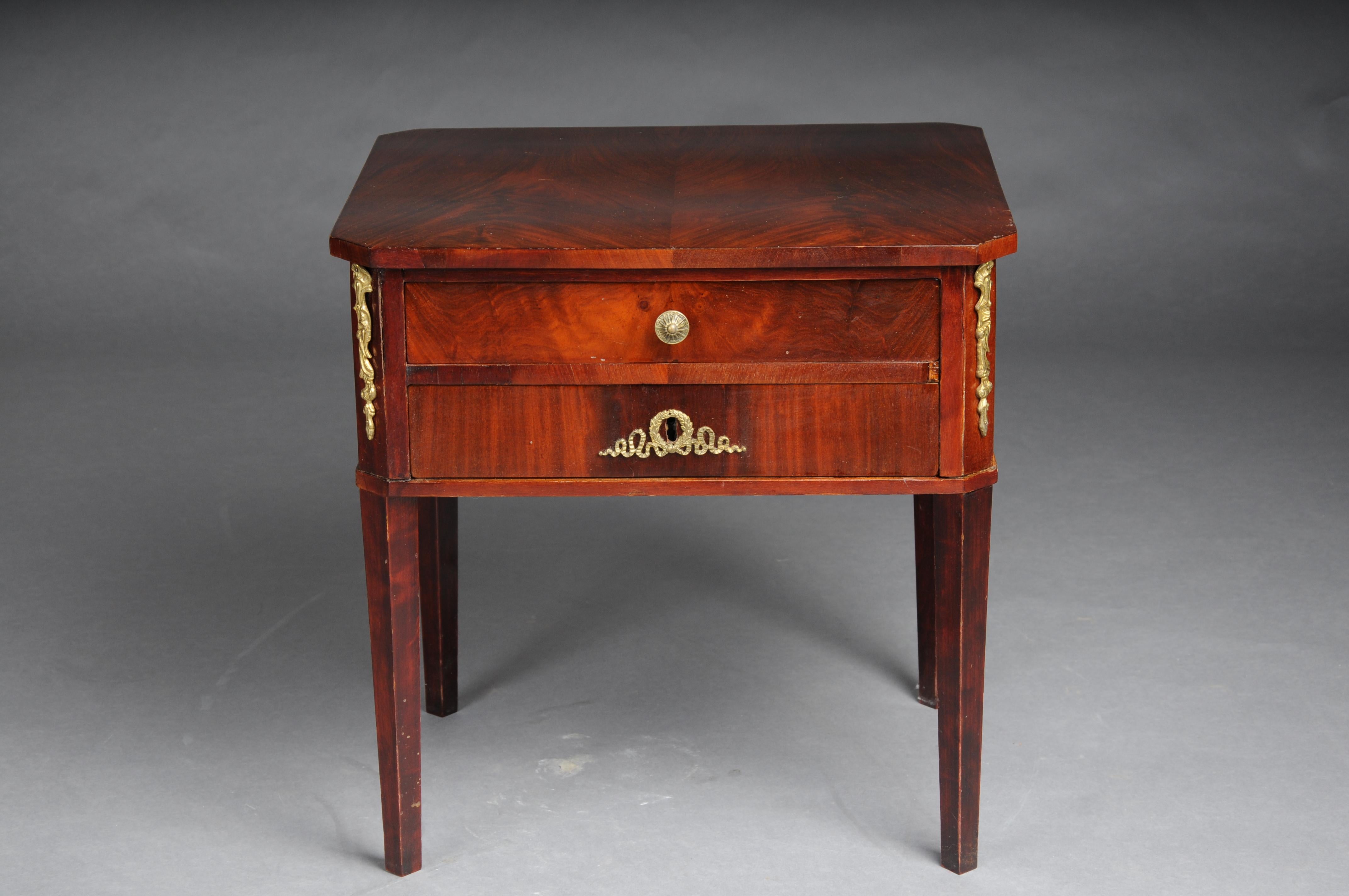 Biedermeier bedside table, circa 1830, mahogany

Solid wood with mahogany veneer. 2 drawer fronts. Gilded brass fittings.
Upper drawer with compartments