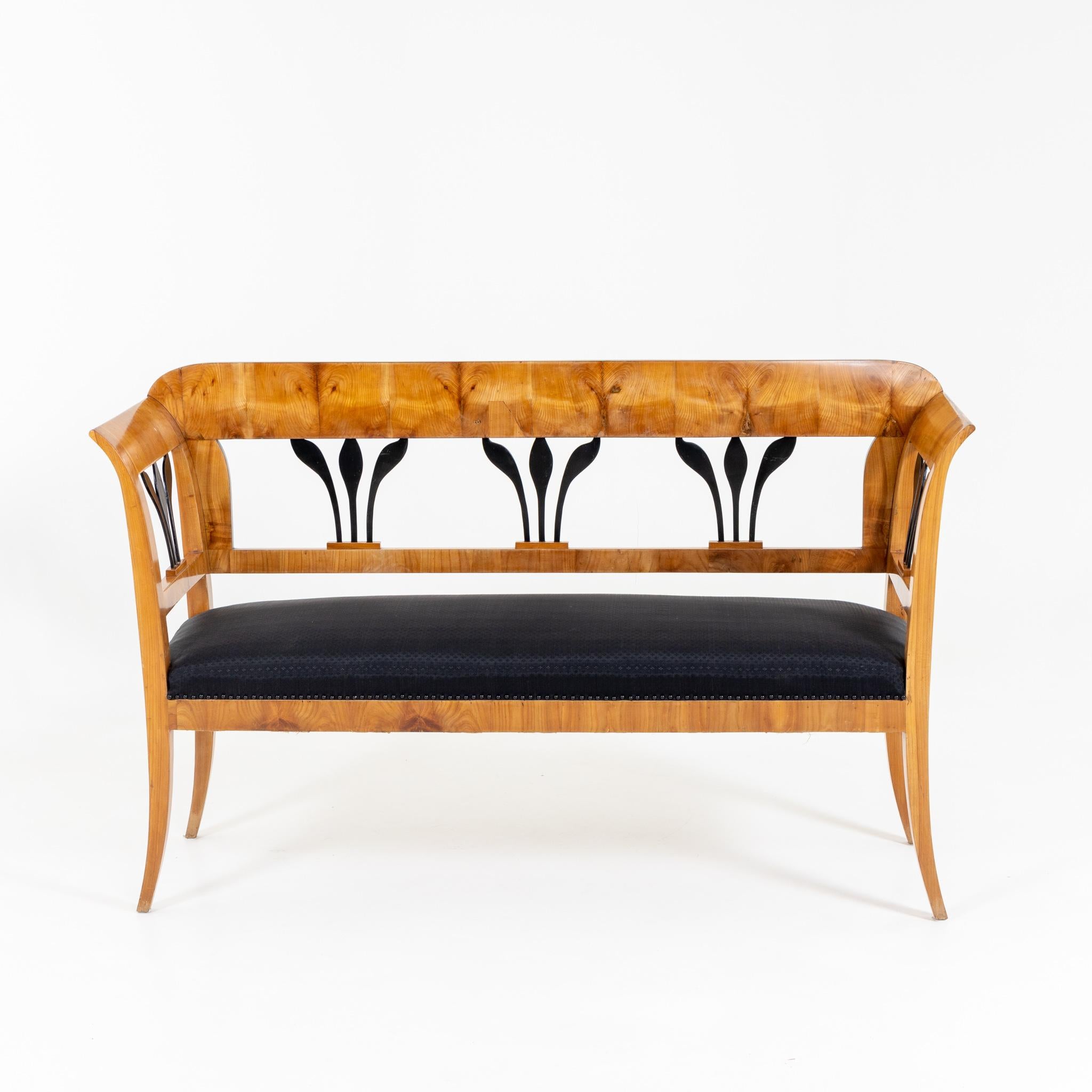 Biedermeier bench with openwork, partially ebonized backrest and upholstered seat. Ash veneered.