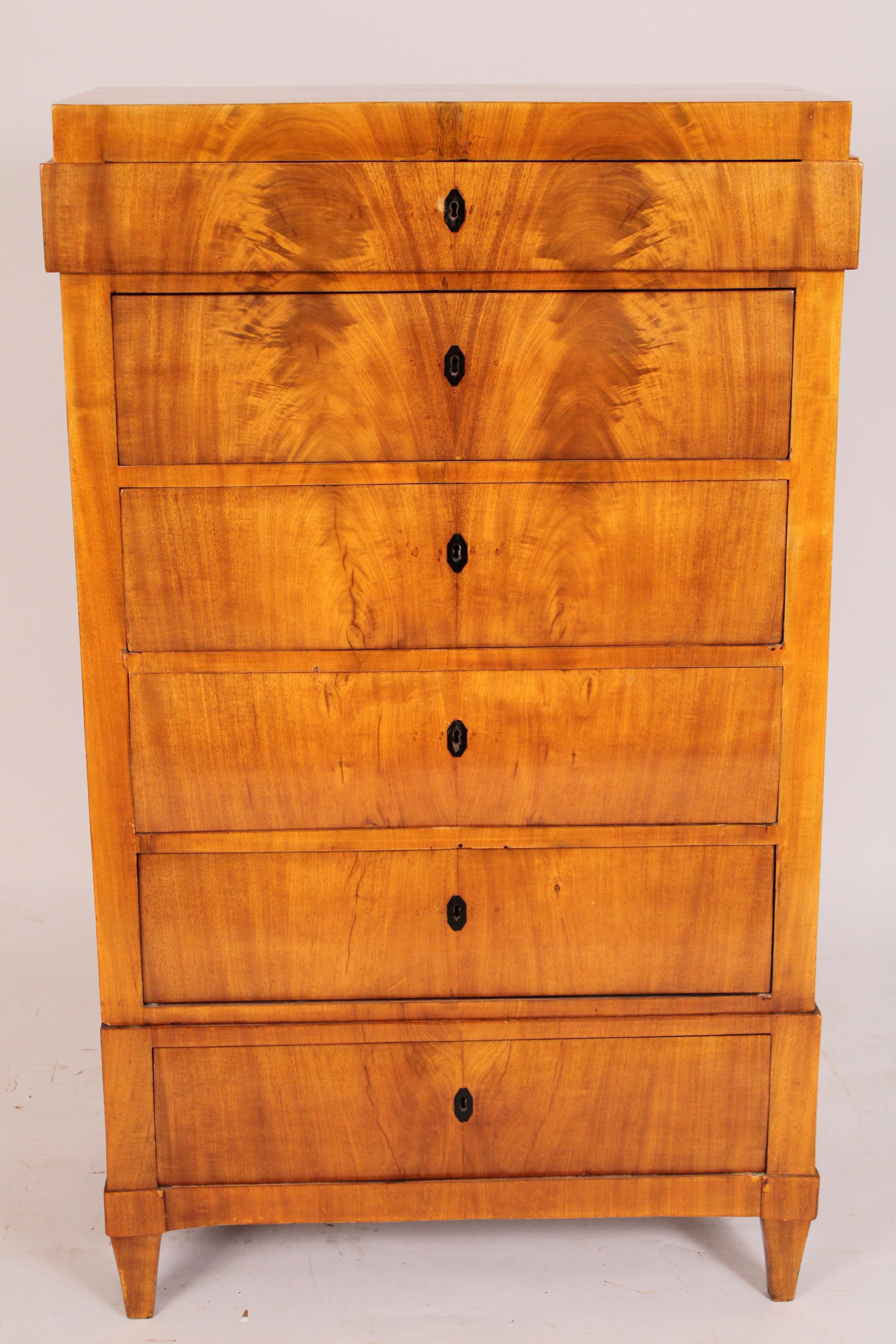 Antique Biedermeier flame mahogany six drawer semanier, circa 1840. With a slightly protruding upper drawer and 5 lower drawers with matching flame grain birch and ebonized escutcheons, resting on square tapered feet. Secondary wood is pine. Hand