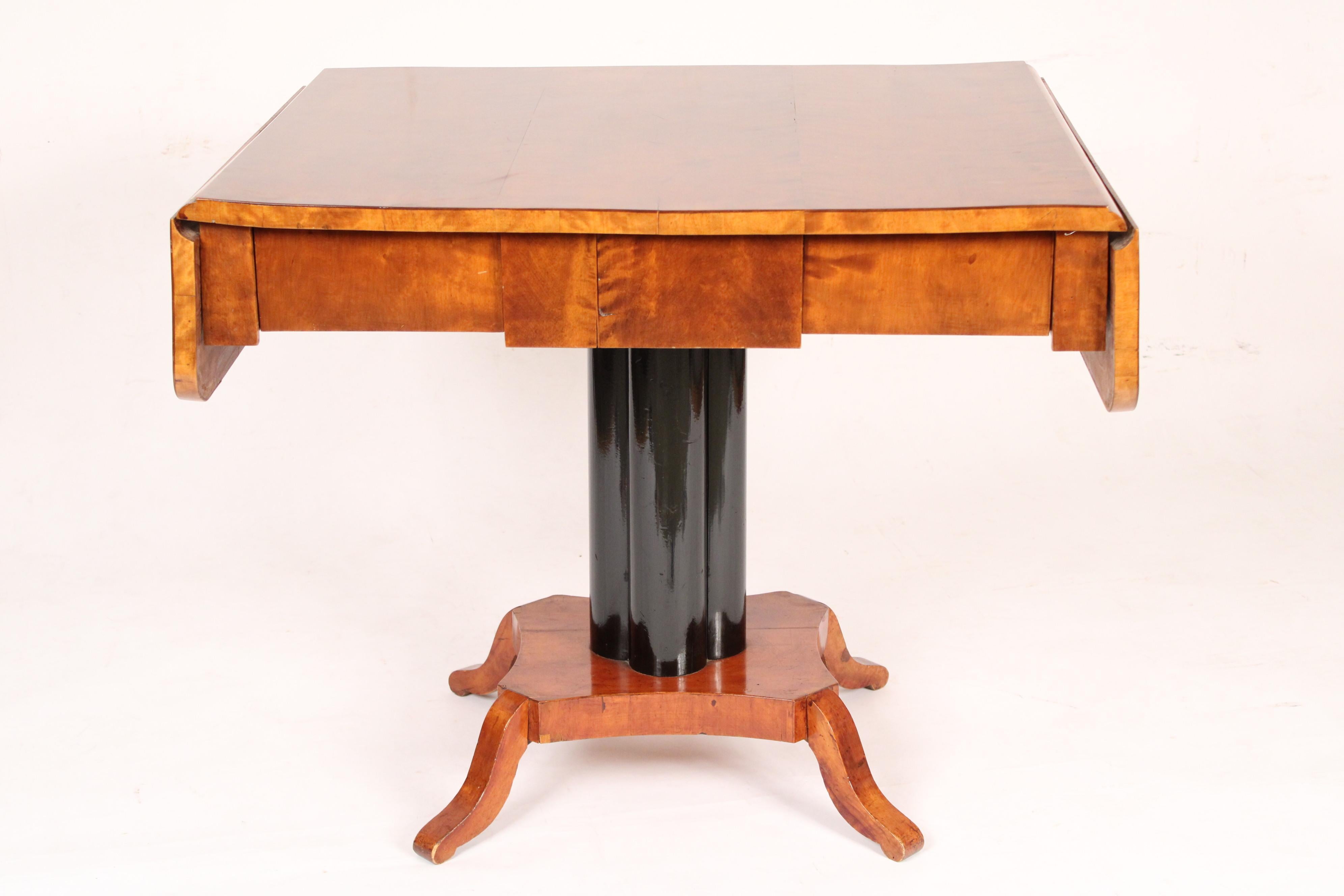 Biederemier birch drop leaf sofa table, circa 1835. With a rectangular birch top with two drop leaves, a drawer in the frieze, an ebonized pedestal and four down swept feet. The birch top and drop leaves have excellent feathering. Hand dovetailed