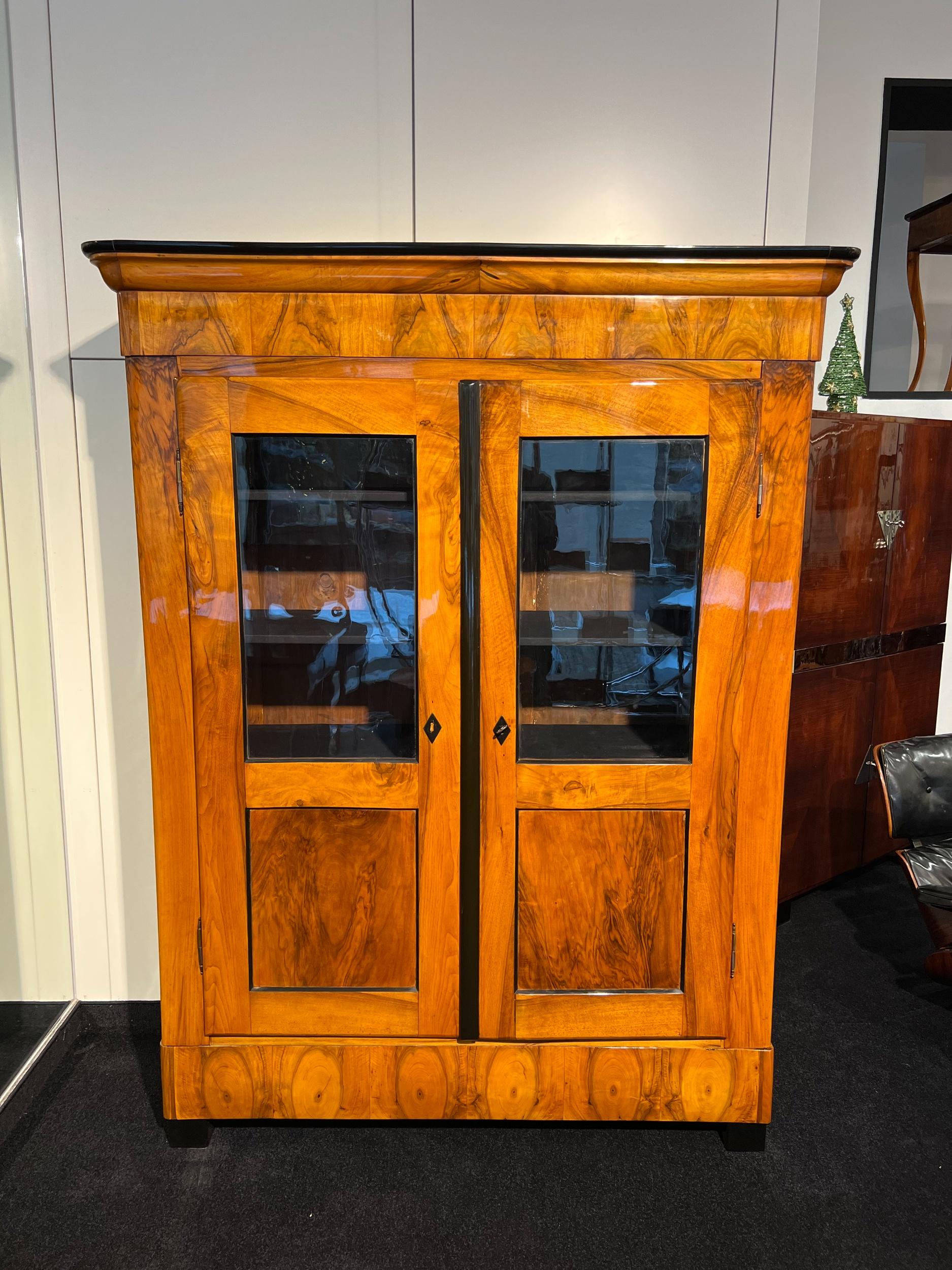 Biedermeier Bookcase, Walnut Veneer, Two-doored, South Germany circa 1830

Walnut veneered and solid with a wonderful veneer grain. 
Original, hand-blown glass windows.
Inside with 4 Inlay Shelves.
Can be completely dismantled for