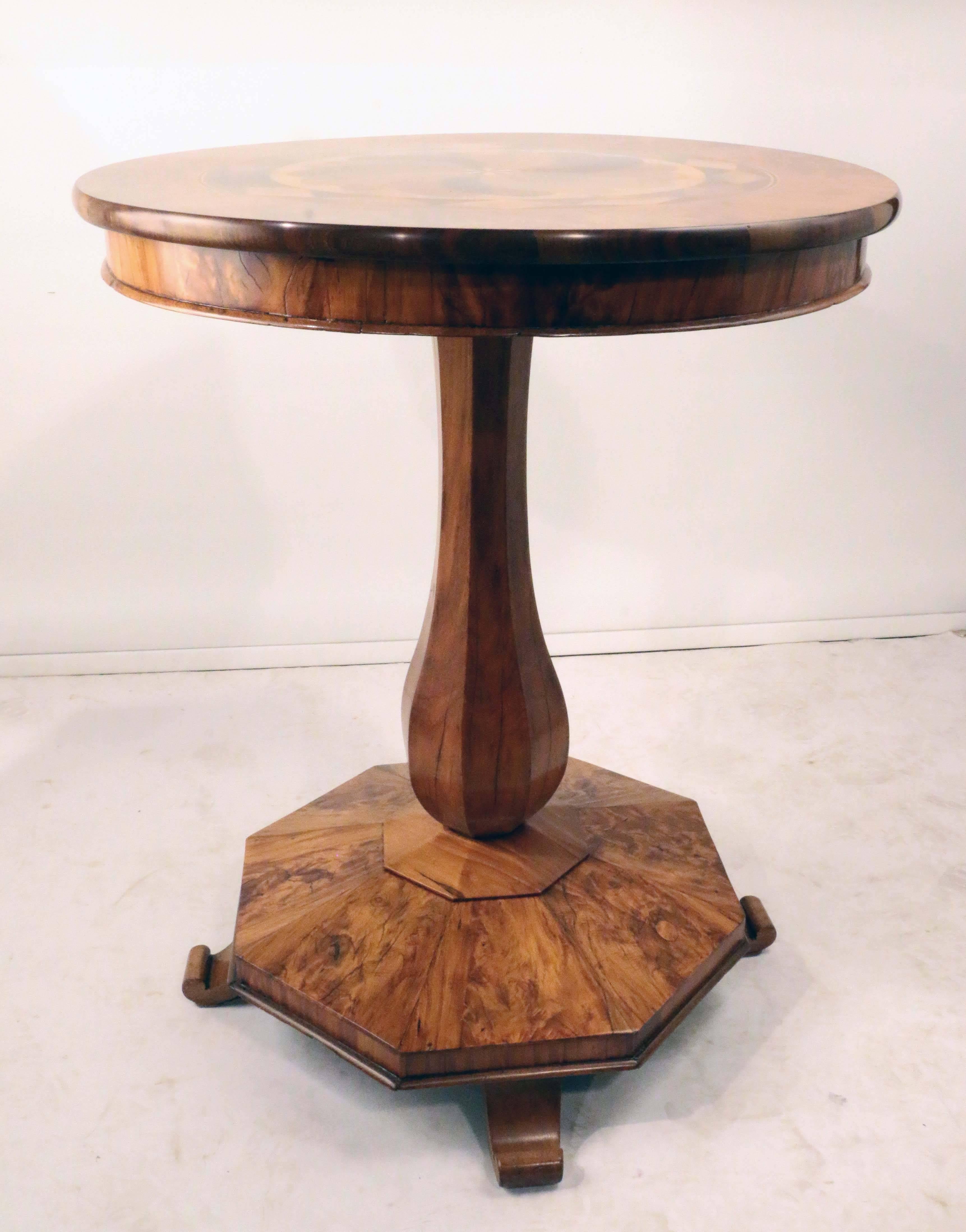 An rare  and elegant Biedermeier round table with stunning specimen top of numerous exotic woods inlaid in spiral leaf design surrounded by a band of diamond- shaped specimens all set in a burl walnut top, supported by a faceted baluster column on a