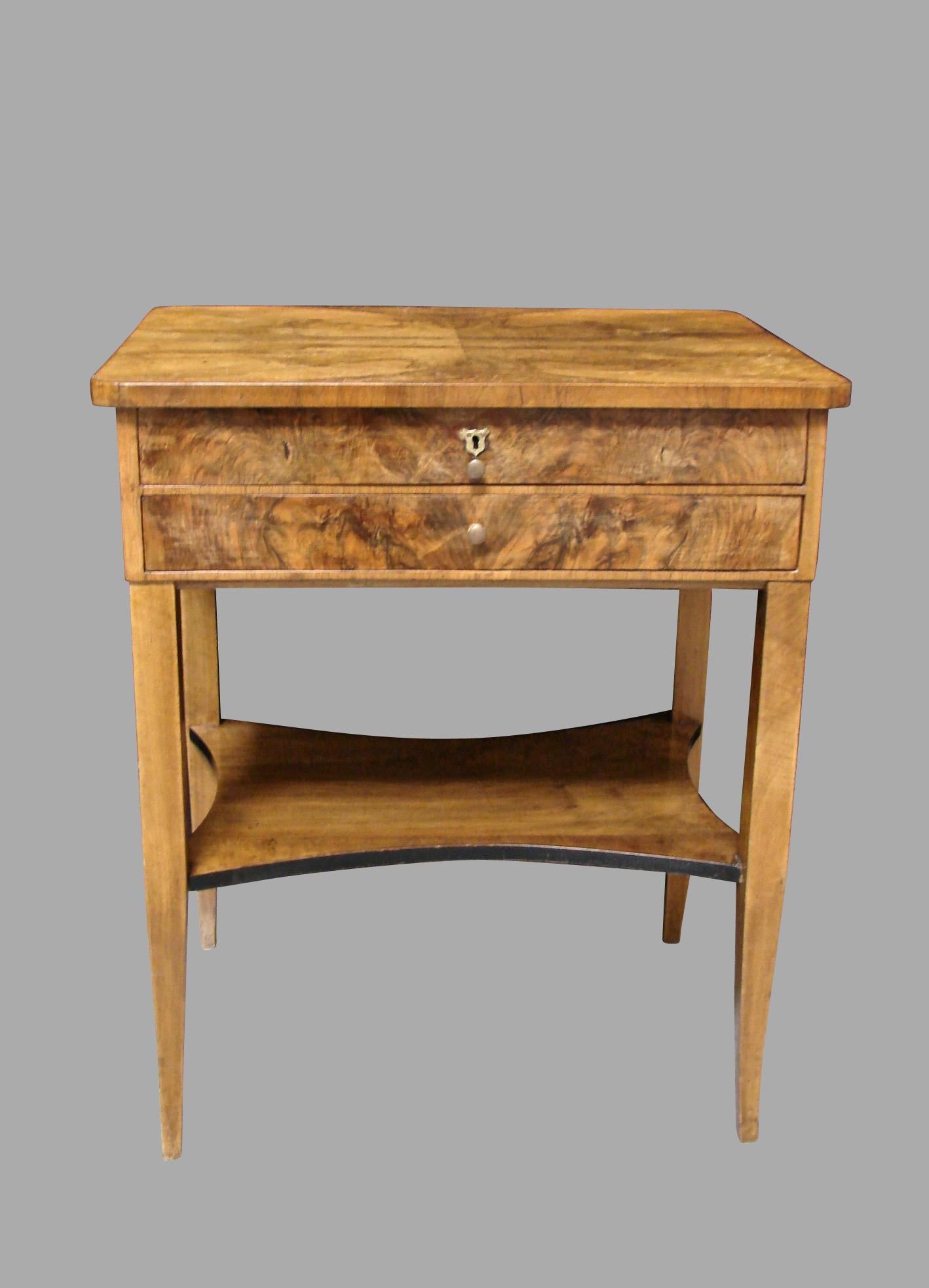 A nice quality Austrian or German Biedermeier work table, the book matched well-figured top over 2 drawers, one fully fitted, above a lower shelf with an ebonized edge, supported on square tapered legs. Circa 1840