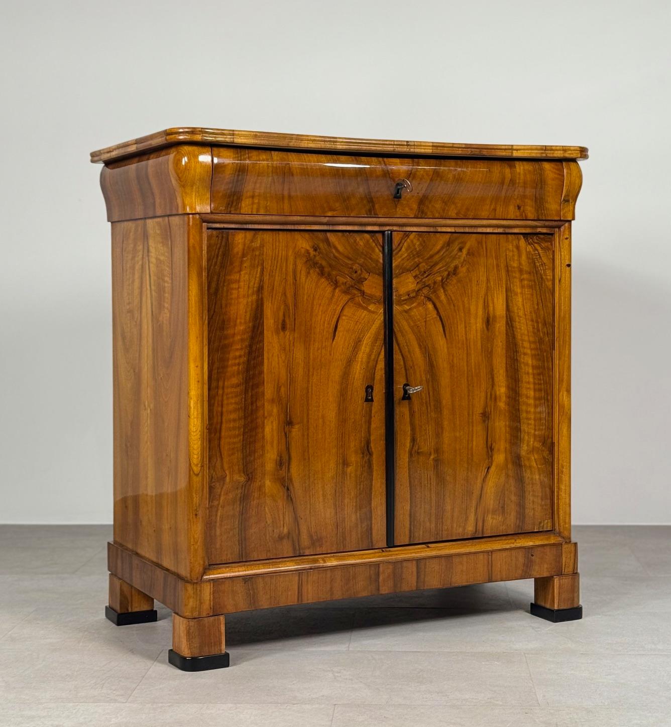 Descubre un tesoro intemporal con este exquisito armario alemán de mediados del siglo XIX. Fabricada con madera de pino duradera y adornada con una impresionante chapa de nogal, esta pieza irradia elegancia y artesanía. Meticulosamente restaurado,