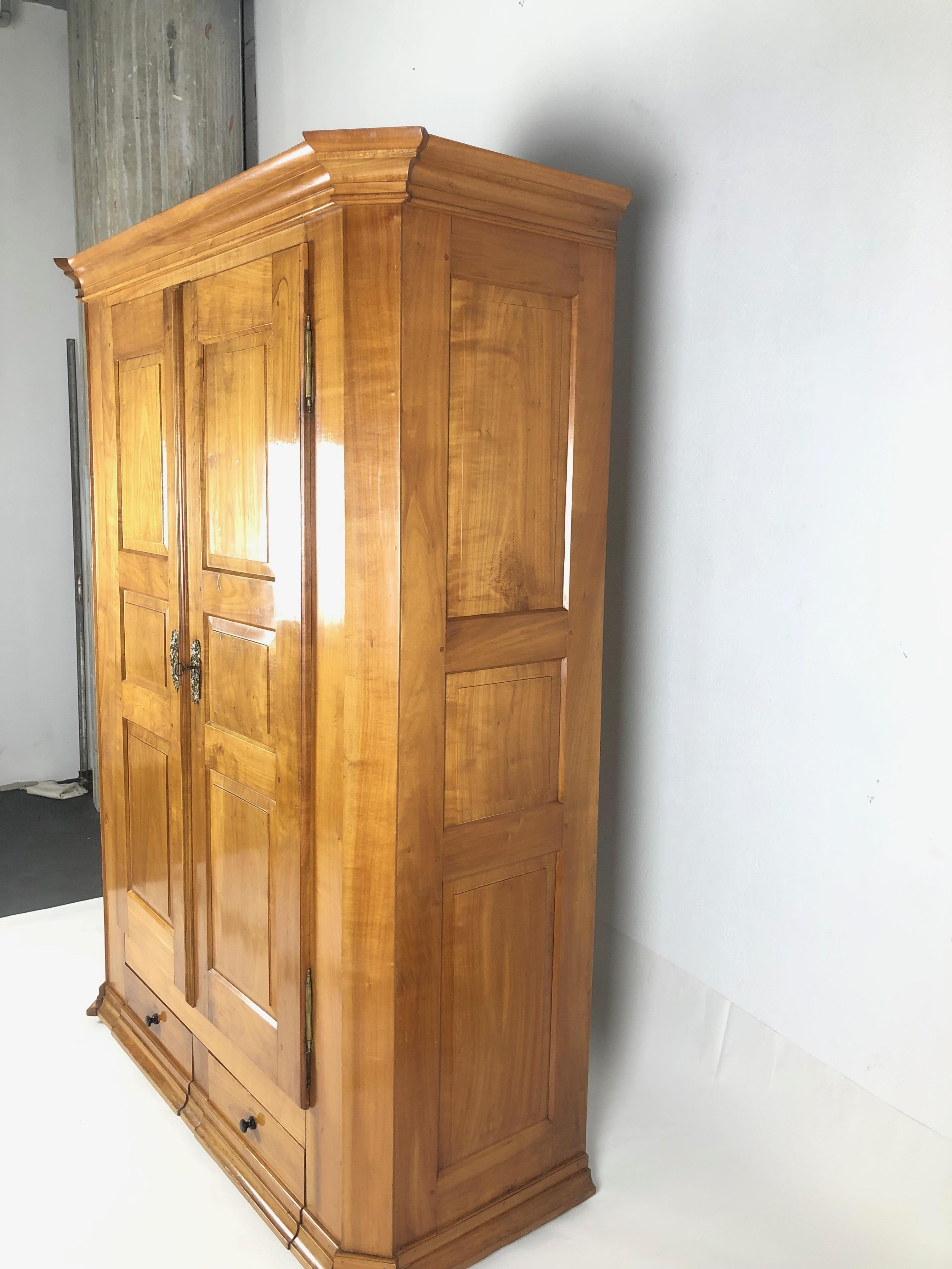 A two-door wooden cabinet from the Biedermeier era in high quality condition, the quality is shown through the refurbished frame and filling. 

With brass fittings and original locks, keys and key plates, along with beveled corners. 

At the