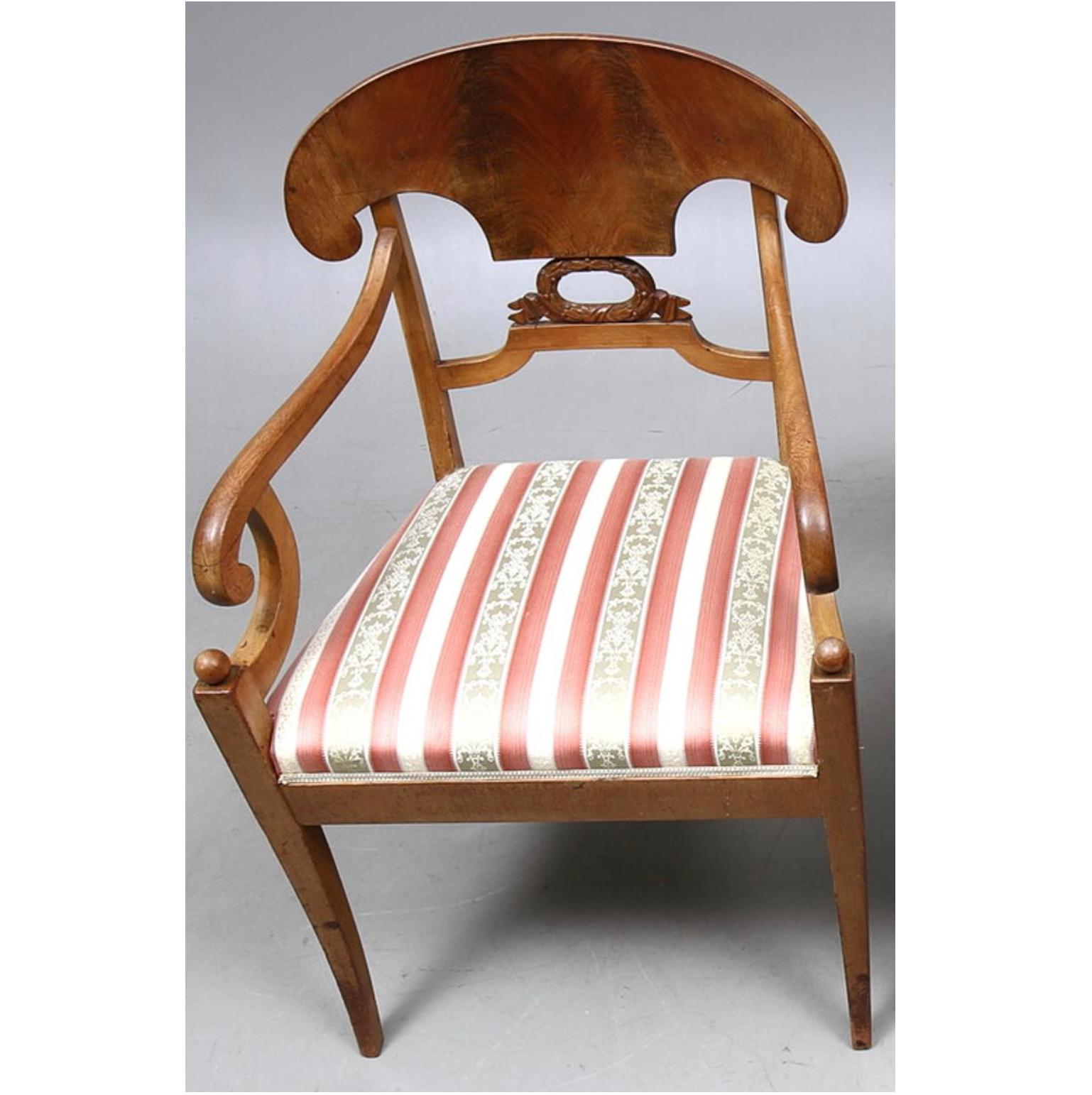Swedish Biedermeier Empire pair of beautiful carver chairs in highest grade quilted mahogany veneers finished in the Classic darker oak color French polish finish with roundel motifs on the arms.

They have fully webbed seats for maximum comfort and