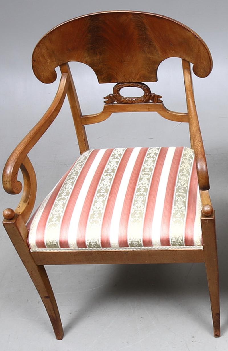 Paire de magnifiques chaises de sculpteur Biedermeier Empire en placages d'acajou matelassé de la plus haute qualité, finis en finition polie française classique de couleur chêne foncé, avec des motifs en ronde-bosse sur les accoudoirs.

Ils sont
