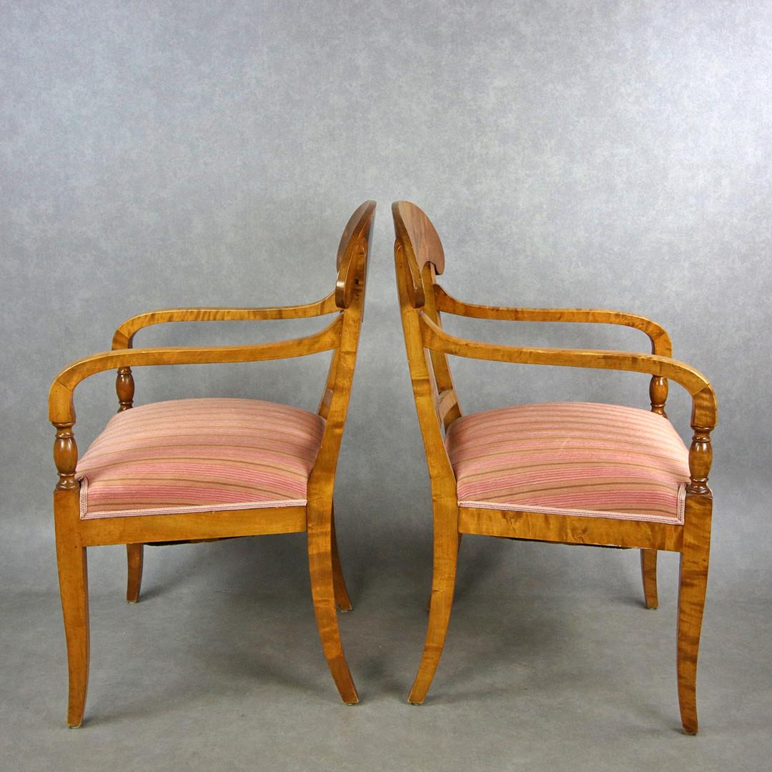 Swedish Biedermeier Empire pair of beautiful carver chairs in highest grade quilted golden birch veneers finished in the Classic honey oak color French polish finish with rounded arms.

They have fully webbed seats for maximum comfort and the gently