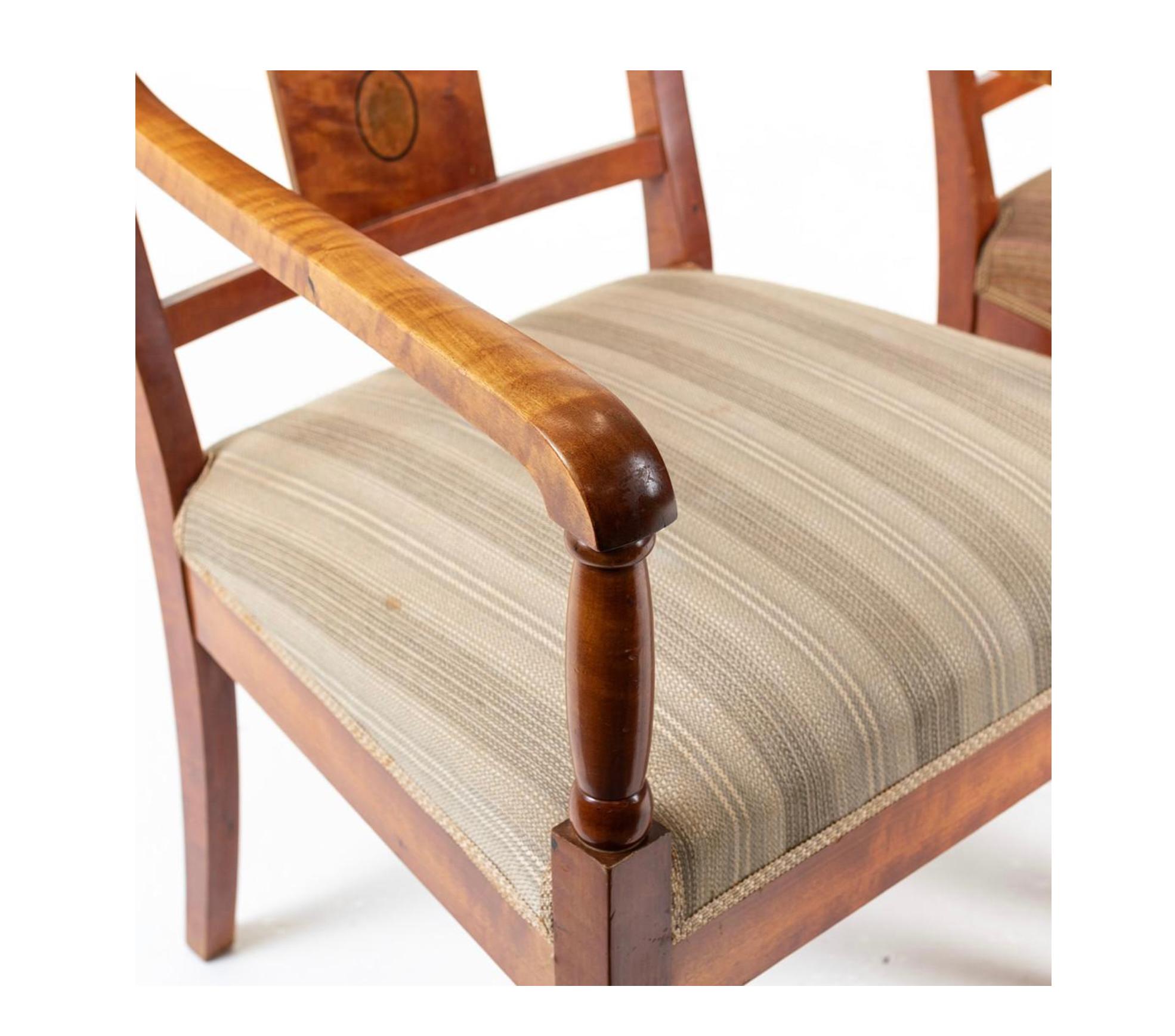 Paire de chaises anciennes Biedermeier Empire en placage de bouleau doré matelassé de la plus haute qualité, finition polie à la française couleur chêne miel classique, avec accoudoirs arrondis.

Ils sont dotés de sièges entièrement sanglés pour un