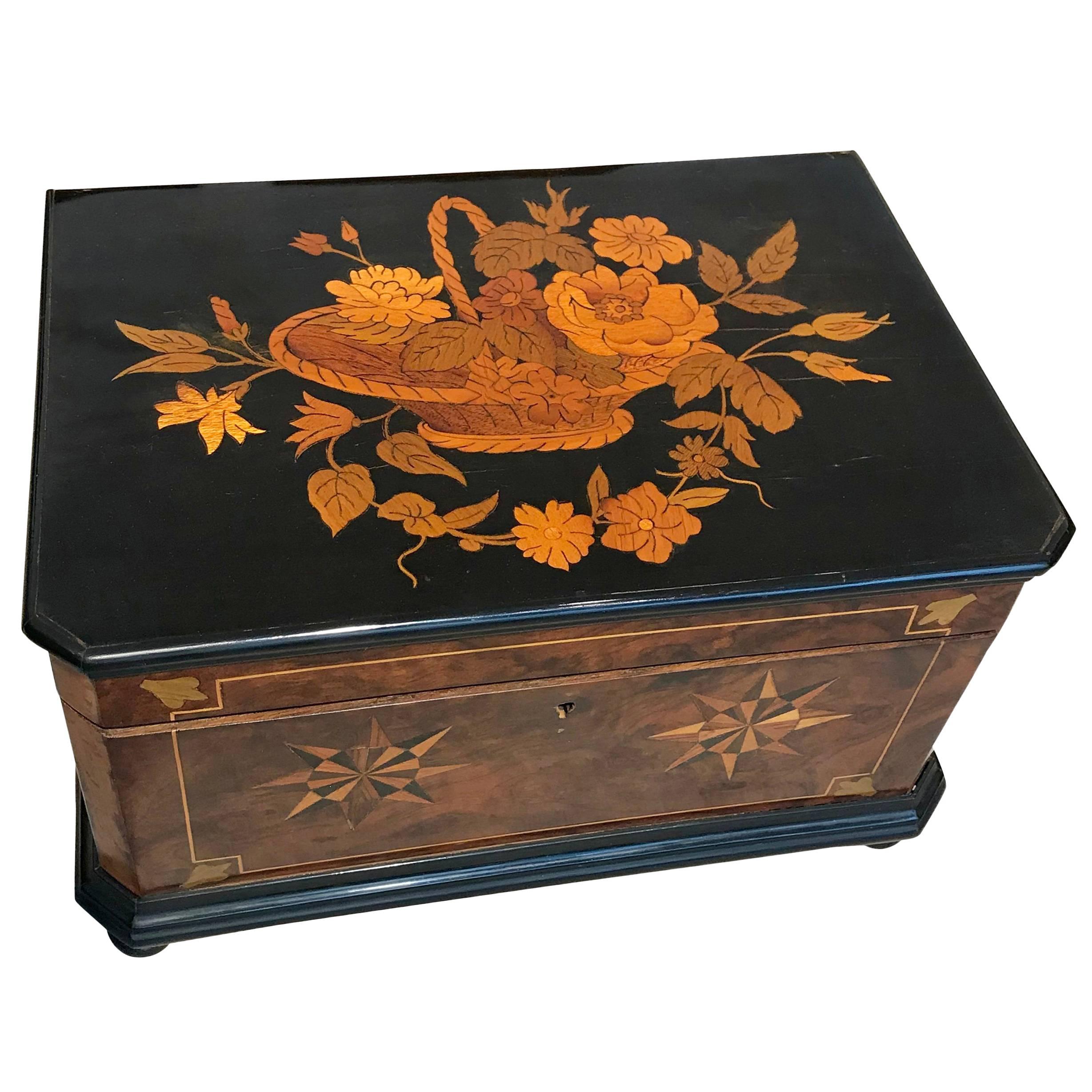 Beautiful late Biedermeier decorative box, circa 1850.
Frame in walnut with top cover made of ebony Veneer and big flower inlays in green-red-yellow toned Fruitwoods.
Side inlays are done in Ebony, Maple and Plum.
It has been hand-polished with