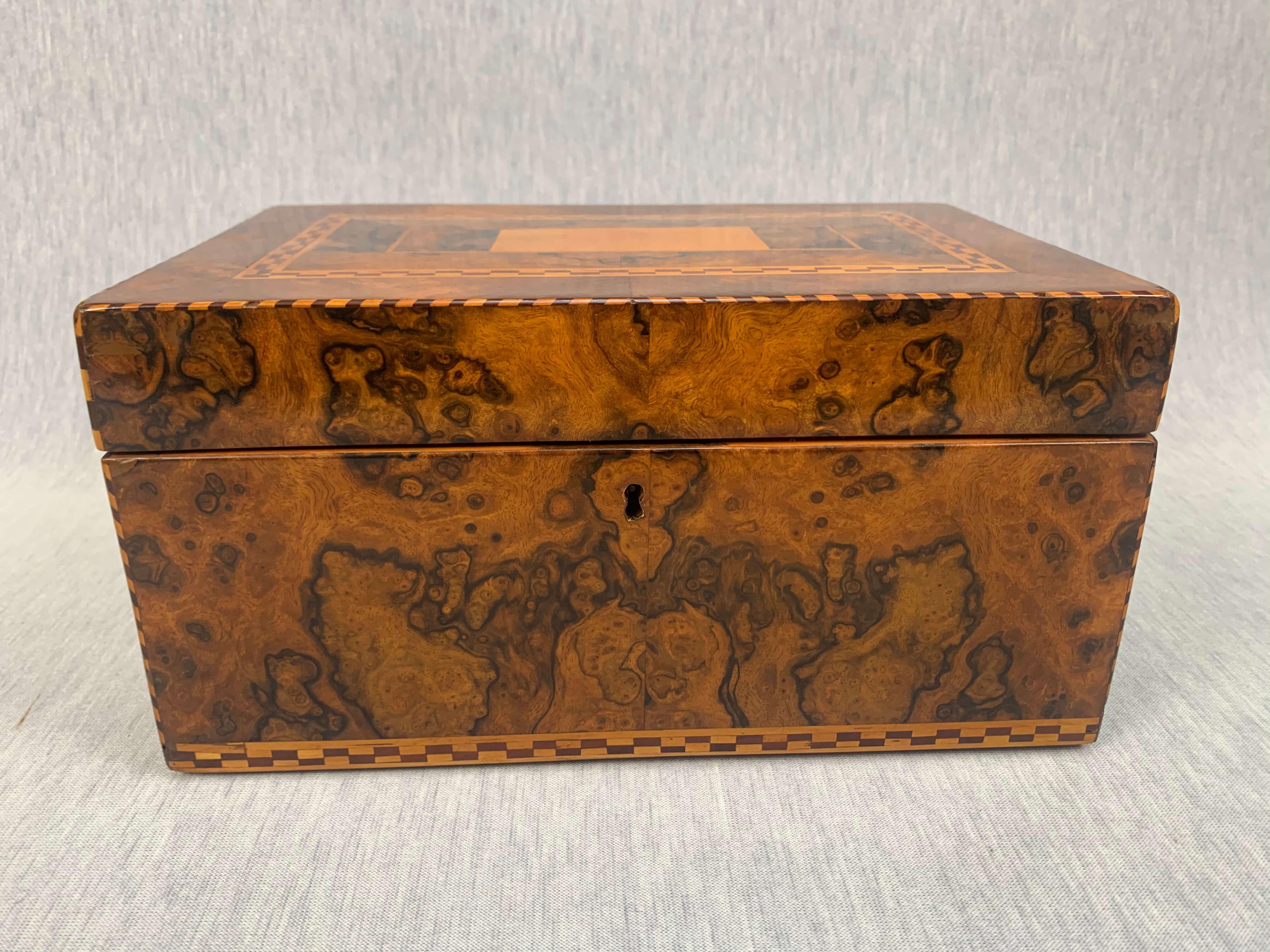 Klassizistische Biedermeier-Schmuckschatulle, Nussbaumwurzelfurnier mit Intarsien, Süddeutschland, um 1820.

Nussbaumwurzel / Wurzelmaser furniert auf Fichte. 
Ahorn, Pflaume um und an den Ecken eingelegt.
Innen mit herausnehmbarem Fach, darunter