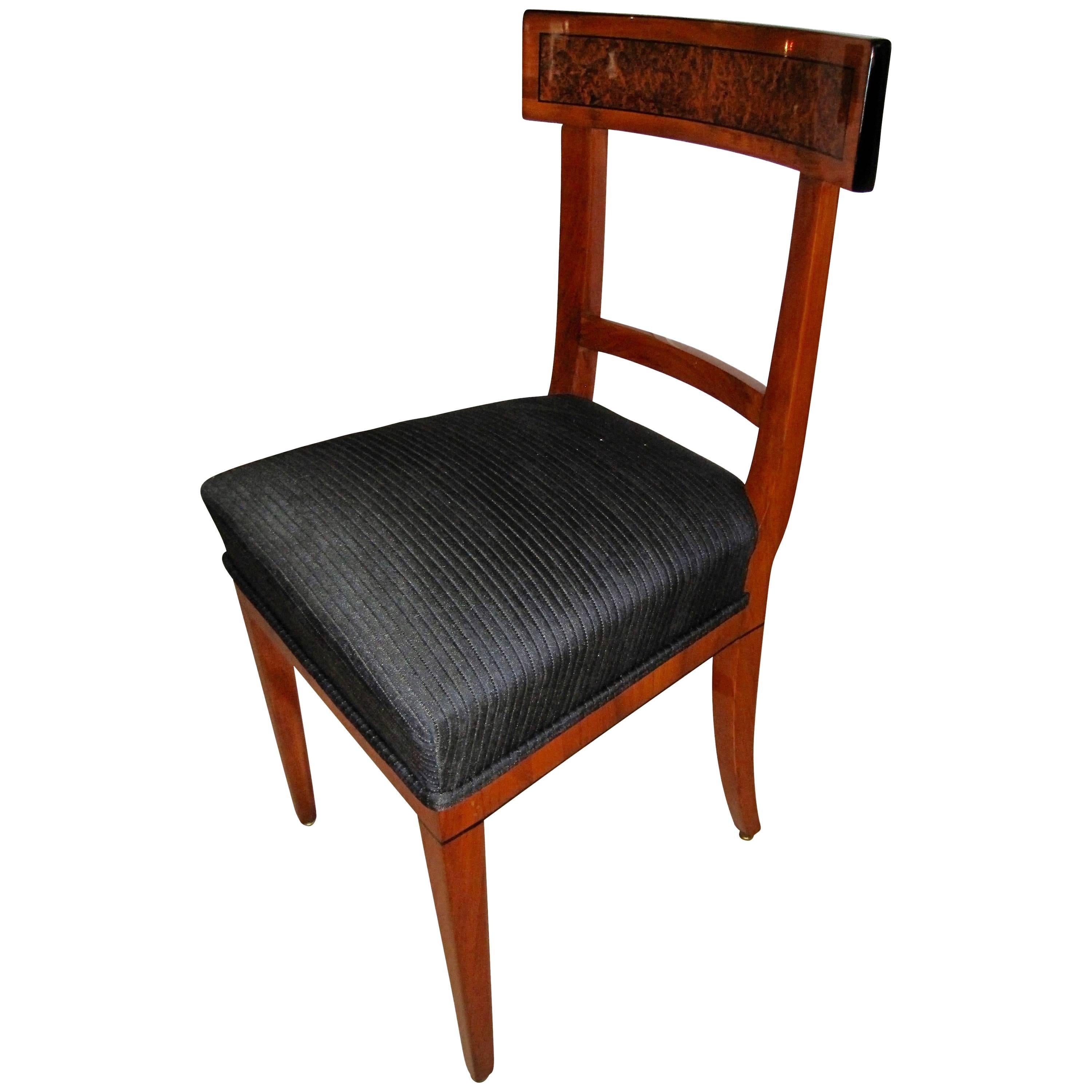 Beautiful and elegant single Biedermeier chair. 
The backrest and frame are veneered with cherry wood and birch roots surrounded by an ebony inlays. 
The legs and back support are cherry solid wood. The sides of the backrest have been