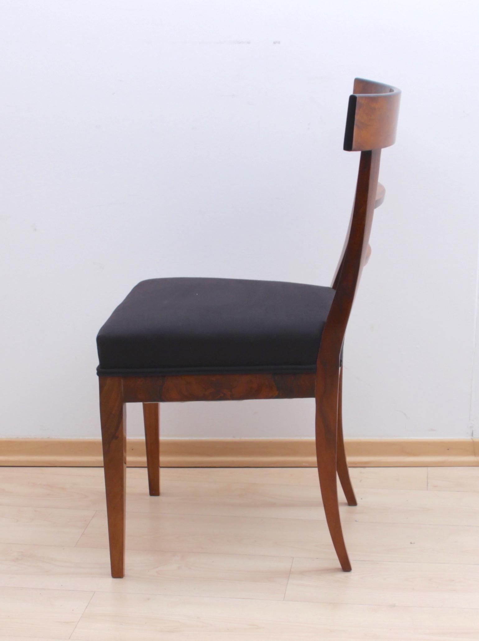 Plain and very elegant Biedermeier chair from South Germany, circa 1820.
Book-matched veneered with walnut of beautiful grain. Two crossbars in the back.
Elegant conical 4-edged legs.
Classic black new upholstery cotton fabric surrounded by