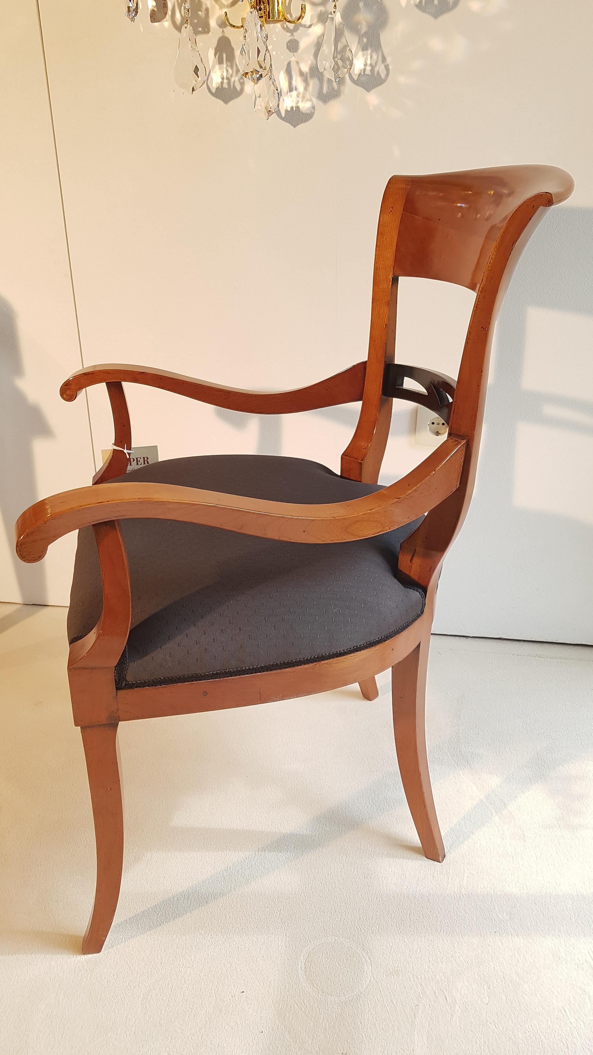 Beautiful petite armchair made of cherry wood with a high gloss polished finish. Convinces with its elegant Biedermeier design and the wonderful hue of the cherrywood. Features curved armrests and feet and a newly upholstered seating area with a