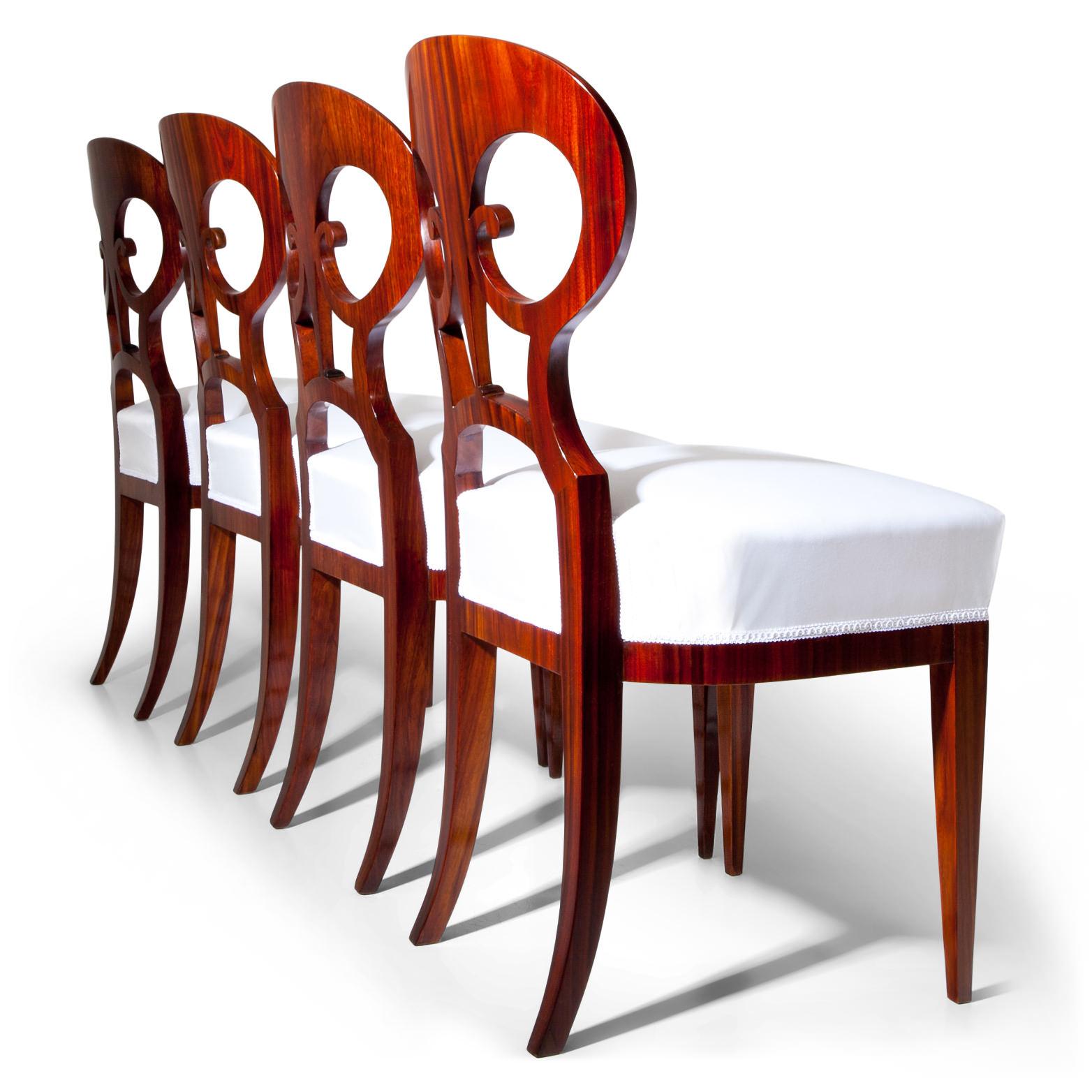 Set of six Biedermeier chairs out of mahogany, standing on tapered legs. The pretzel-shaped backrests show ebonized thread inlays. The seats were reupholstered with a white fabric.