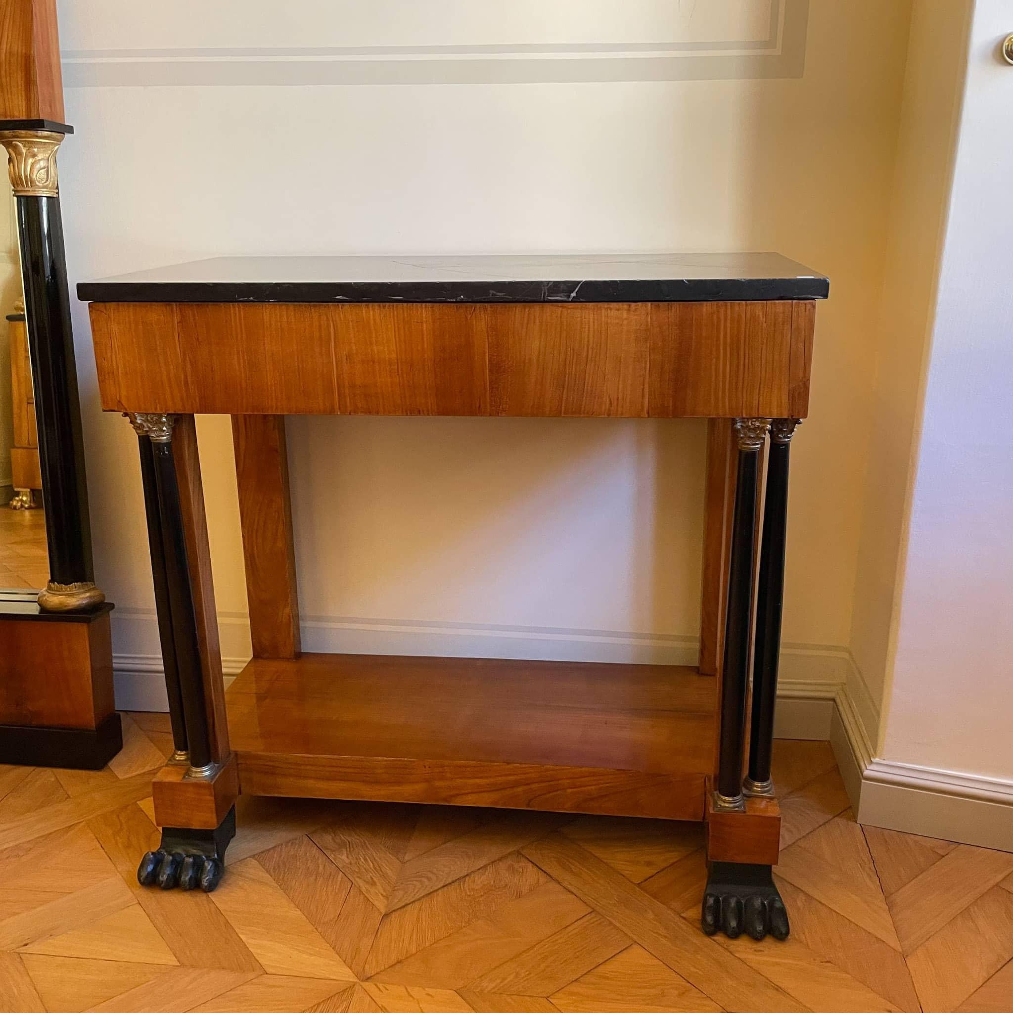 Elegant console on full-plastic paw feet is supported by ebonized double solid columns with very finely crafted brass capitals and hoop bases. Frame drawer. Original marble top. Provenance: formerly Palais Lichtenstein, Vienna.