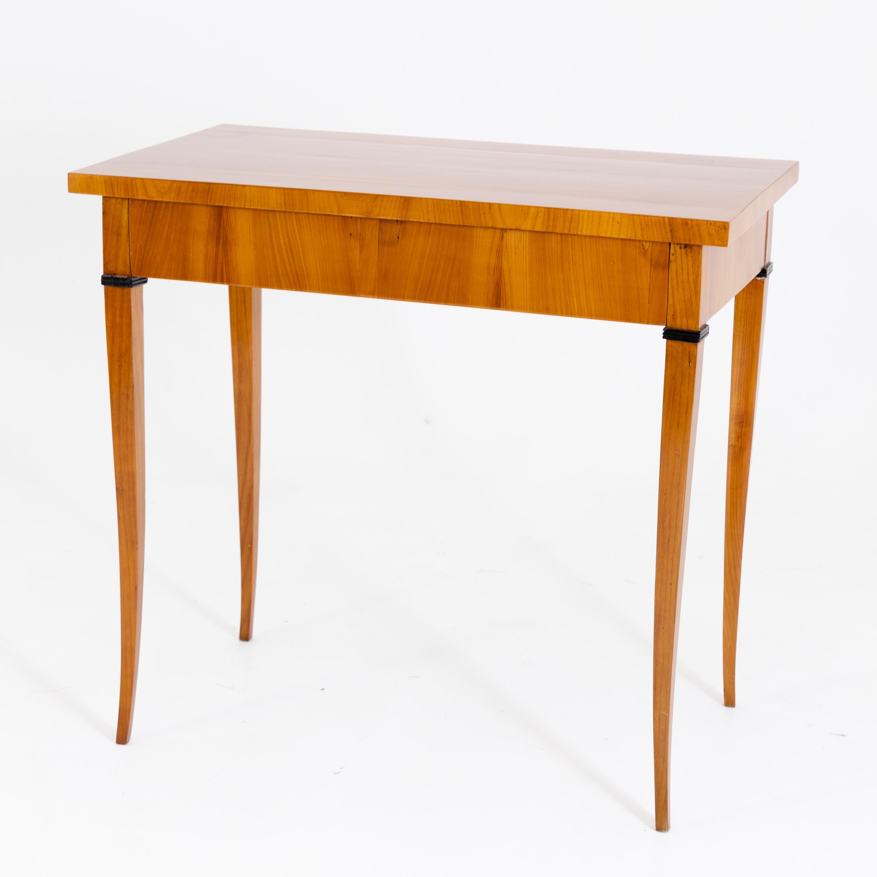 Side table standing on four high slightly flared legs with a rectangular tabletop and smooth frame as well as one drawer. Cherry veneered and hand polished.
  
