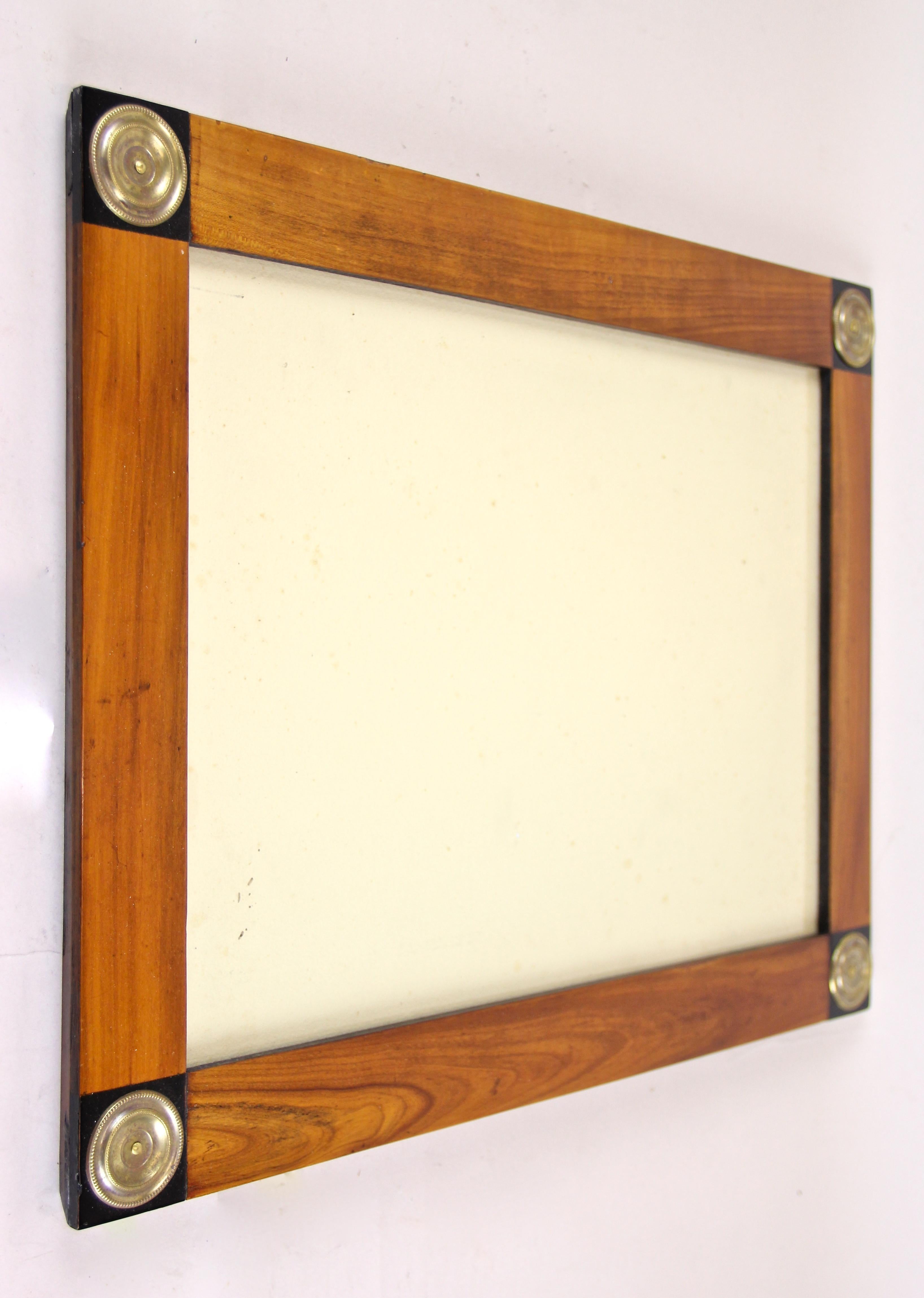 Charming Biedermeier cherrywood picture frame with brass applications out of the transition from Empire to Biedermeier in Vienna/ Austria circa 1815-1820. This lovely early 19th century frame has an overlapped substructure made of spruce wood and
