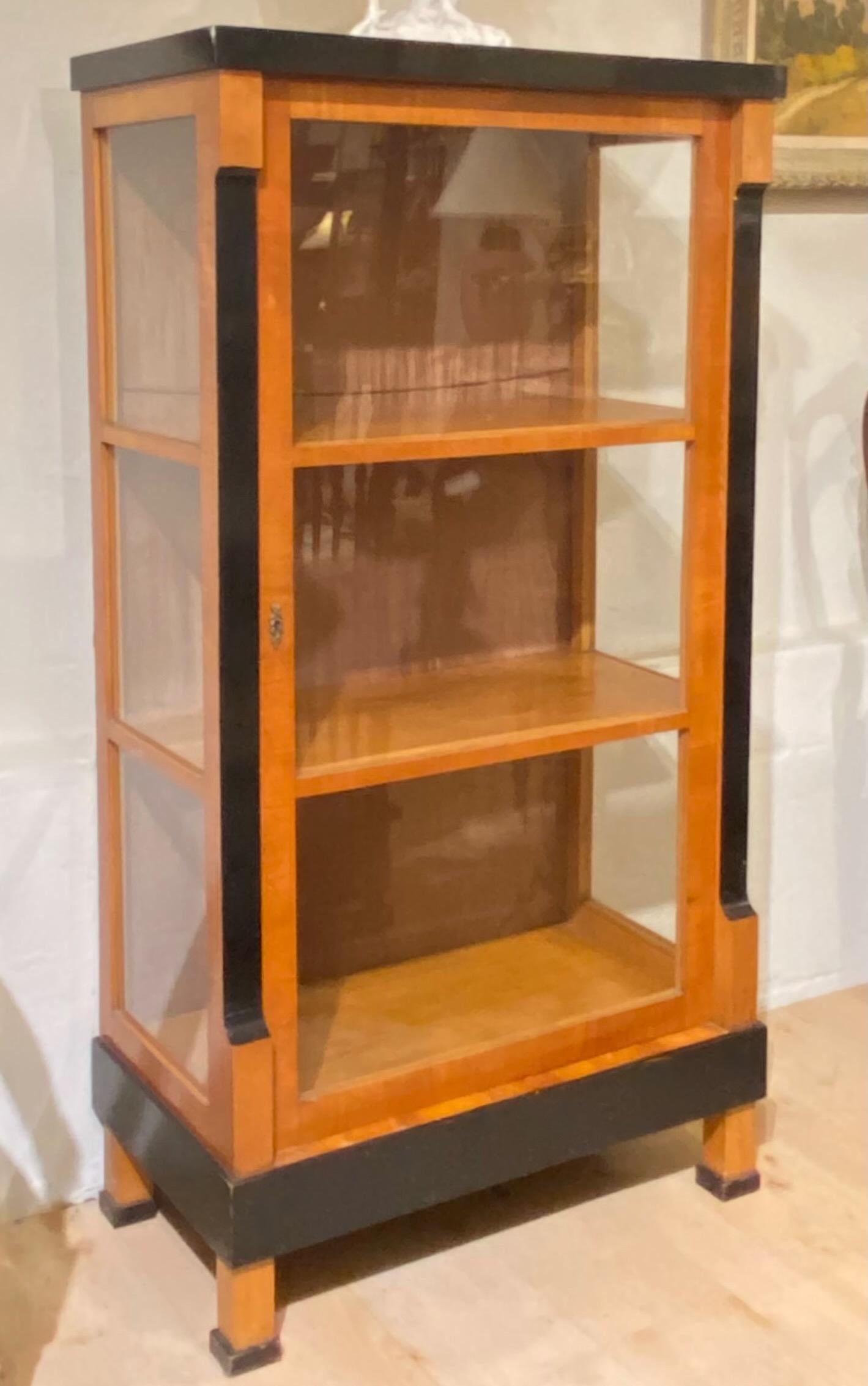 A cherrywood Biedermeier style vitrine or cabinet with ebonized detail.
Small easy to use size that would work in most rooms.
Glass front and sides with three shelves. The depth of each interior shelf is 13.75 inches.
Austrian, early 19th century,