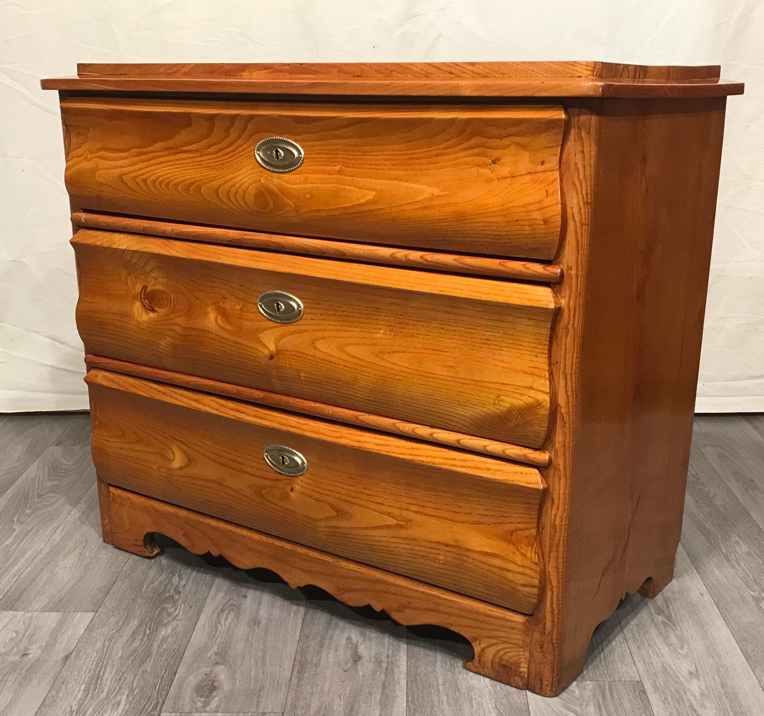 This Biedermeier chest of drawers dates back to 1840 and is an example of a chest from the late phase of the Biedermeier style. It comes from Southern Germany. The curved profile of the drawers is the special feature of this pretty chest. It is