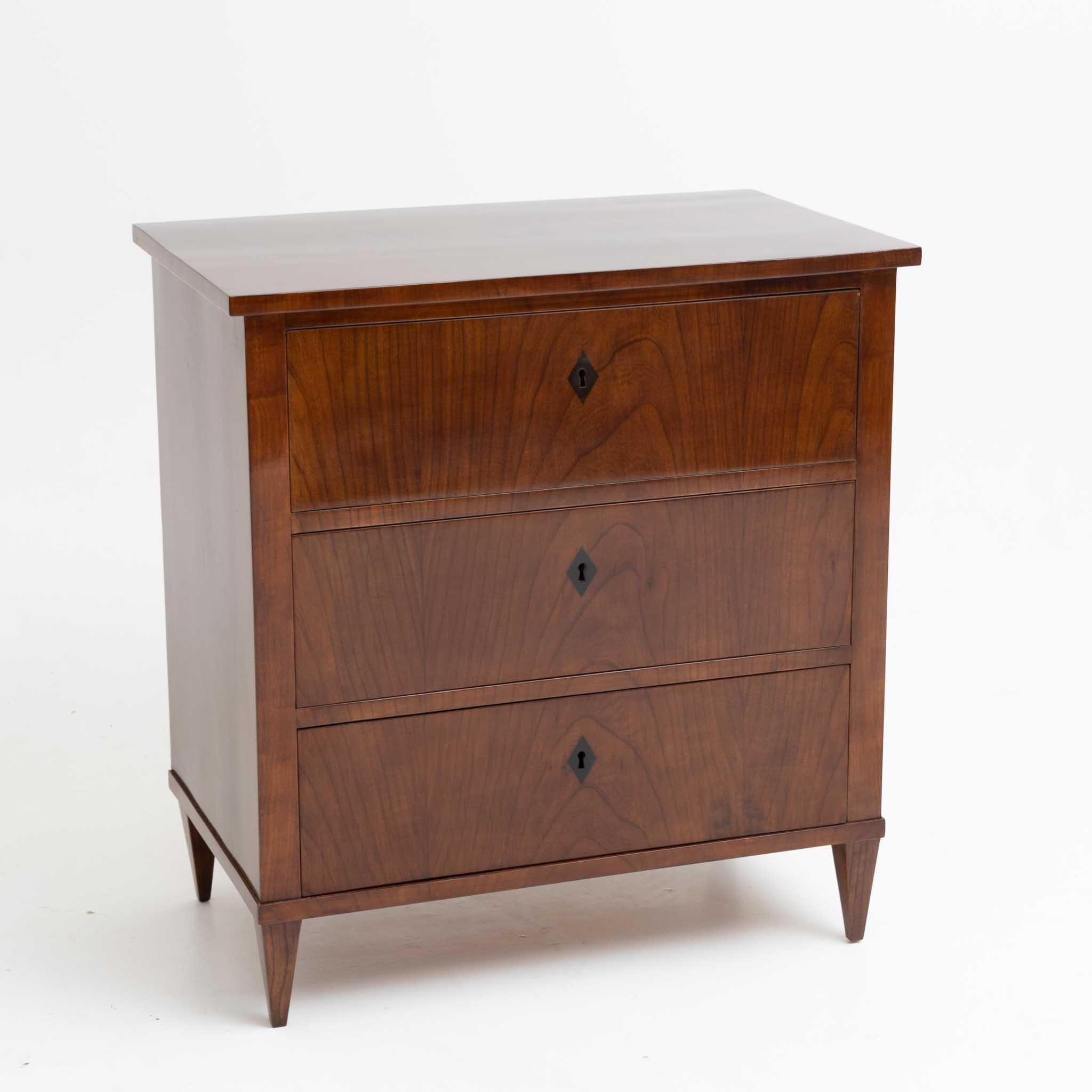 Narrow Biedermeier chest of drawers with three drawers and ebonized key plates, veneered in walnut.