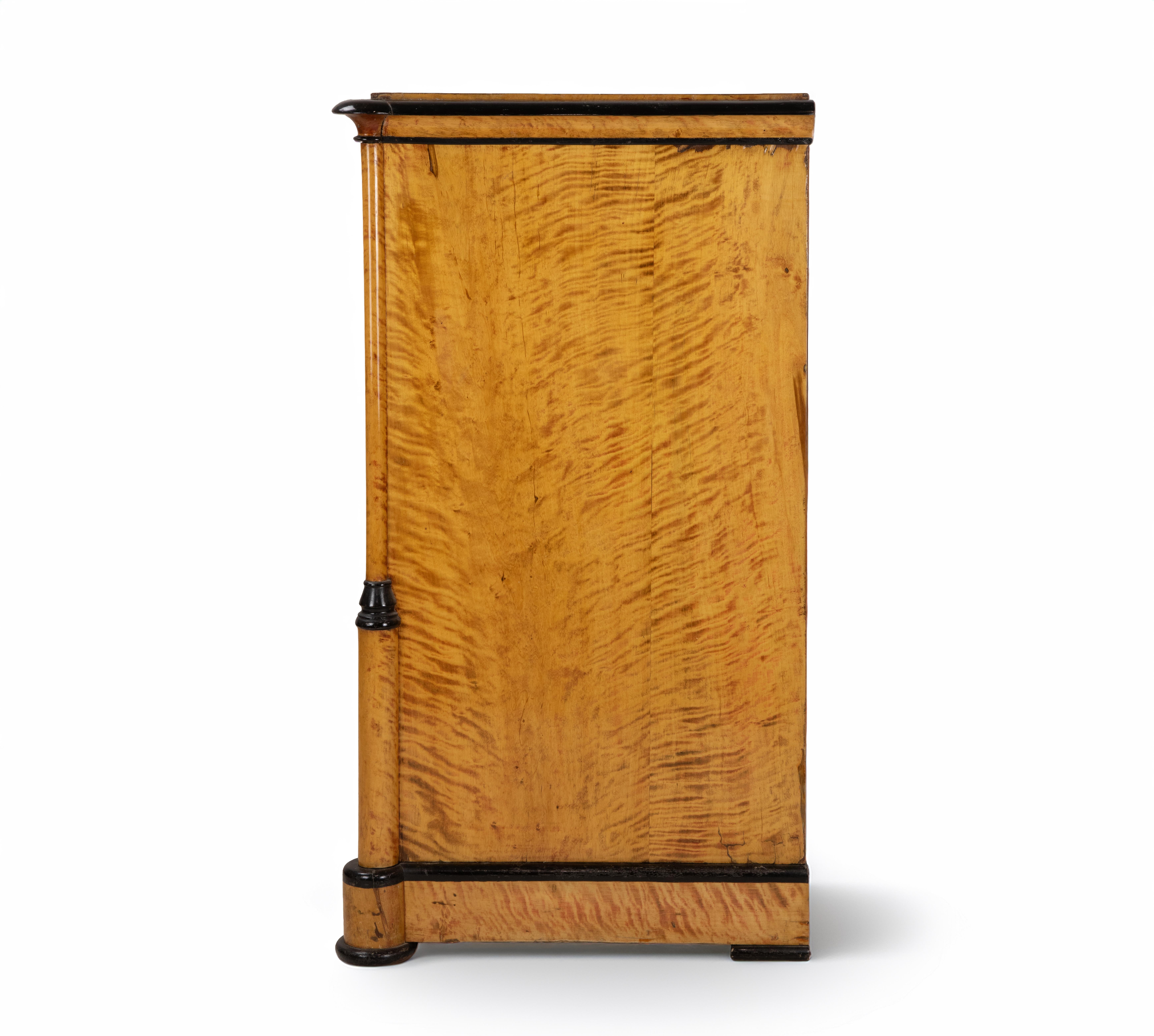Eine raffinierte Biedermeier-Kommode aus der Mitte des 19. Jahrhunderts, die die elegante Schlichtheit und Handwerkskunst des nordeuropäischen Designs des frühen 19. Jahrhunderts verkörpert.

Ahornfurnier, Akzente aus ebonisiertem Holz.

Die