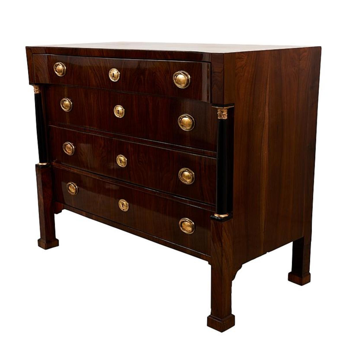 Questo cassettone in noce Biedermeier dell'inizio del XIX secolo, con i suoi accessori originali e le sue colonne dorate ed ebanizzate, è davvero notevole. Un design classico con dettagli davvero eccezionali.