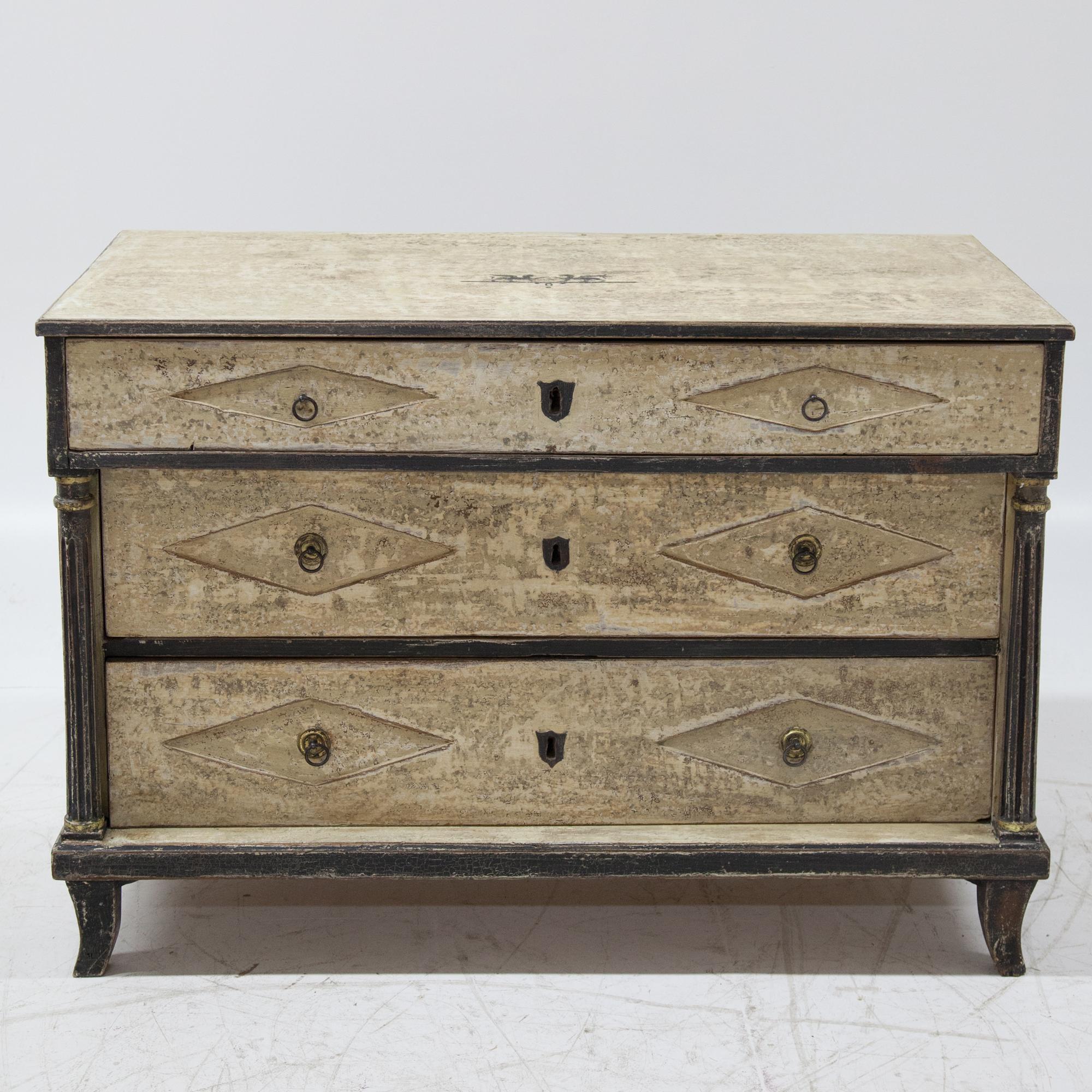 Franconian Biedermeier chest of drawers with three drawers on flared feet with fluted full columns and a top drawer resting on top. Solid oak. The beige paint has been redesigned according to historical models and has a decorative patina.