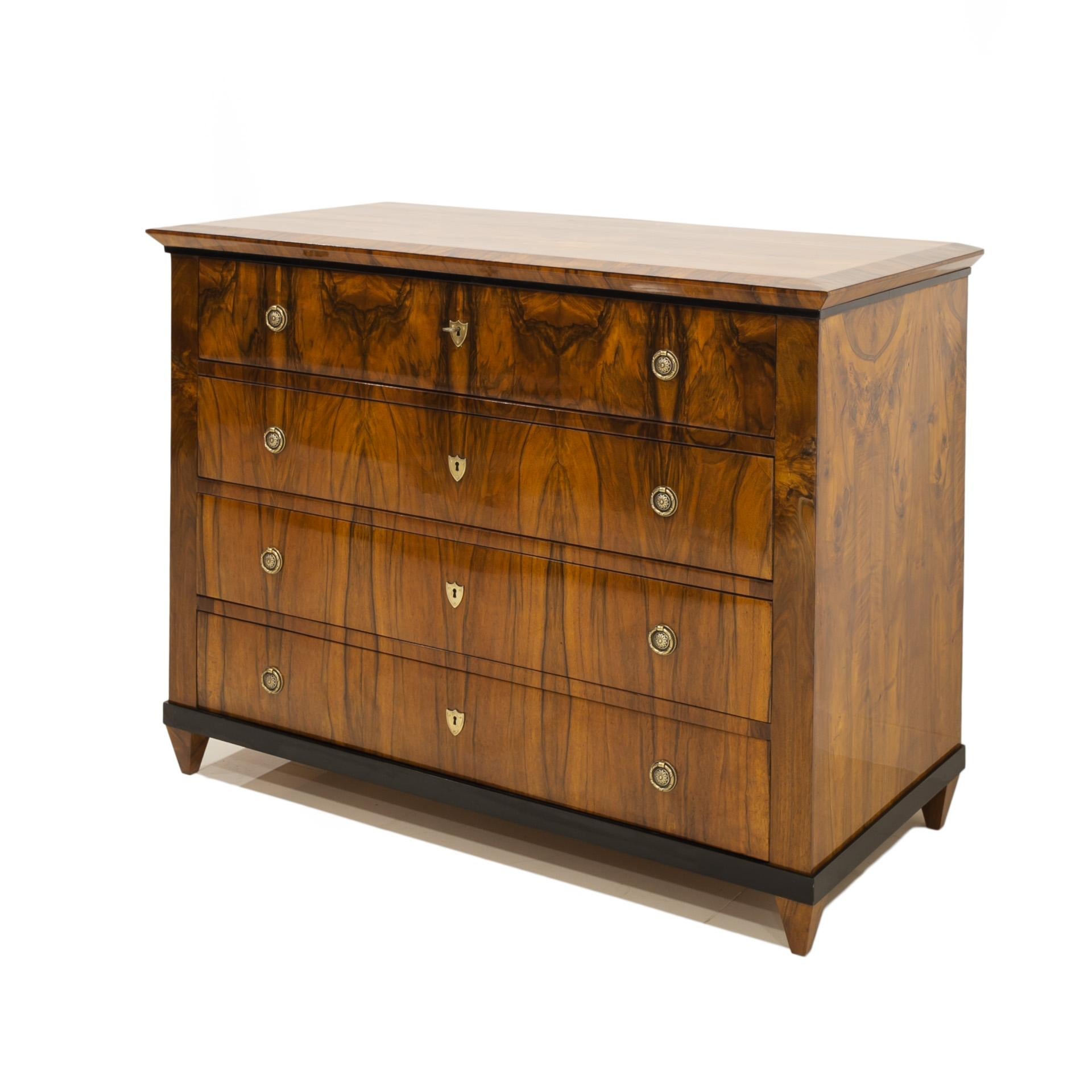 Biedermeier style chest of drawers from 19th century, circa 1830s. This piece of furniture comes from Germany. It was made of coniferous wood and veneered with beautiful walnut wood. It features 4 spacious drawers. The chest of drawers has undergone