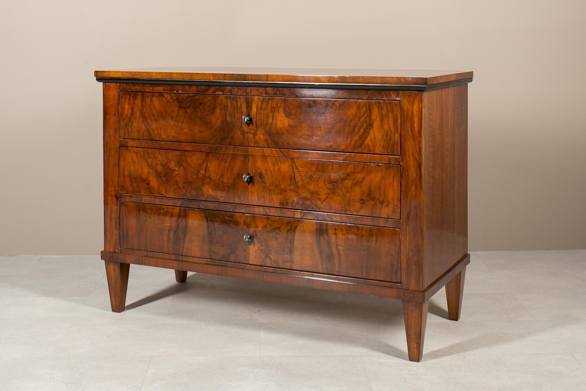 This Biedermeier chest of drawers was made in 19th Century, originating from Germany. Crafted with precision and attention to details, construction made of solid wood adorned with beautiful walnut veneer. Admire its distinguished features, including