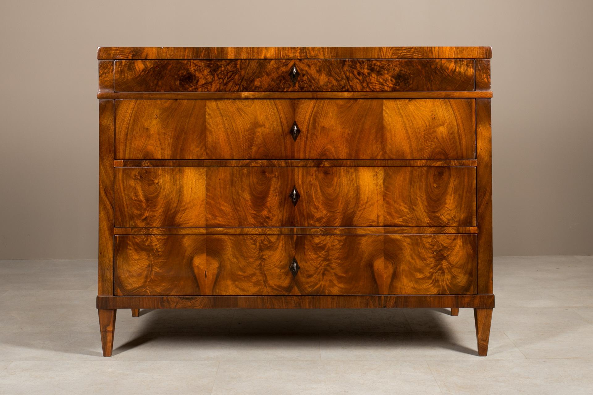 This Biedermeier chest of drawers was made in 19th Century, originating from Germany. Crafted with precision and attention to details, construction made of solid wood adorned with exceptional walnut veneer. Admire its distinguished features,