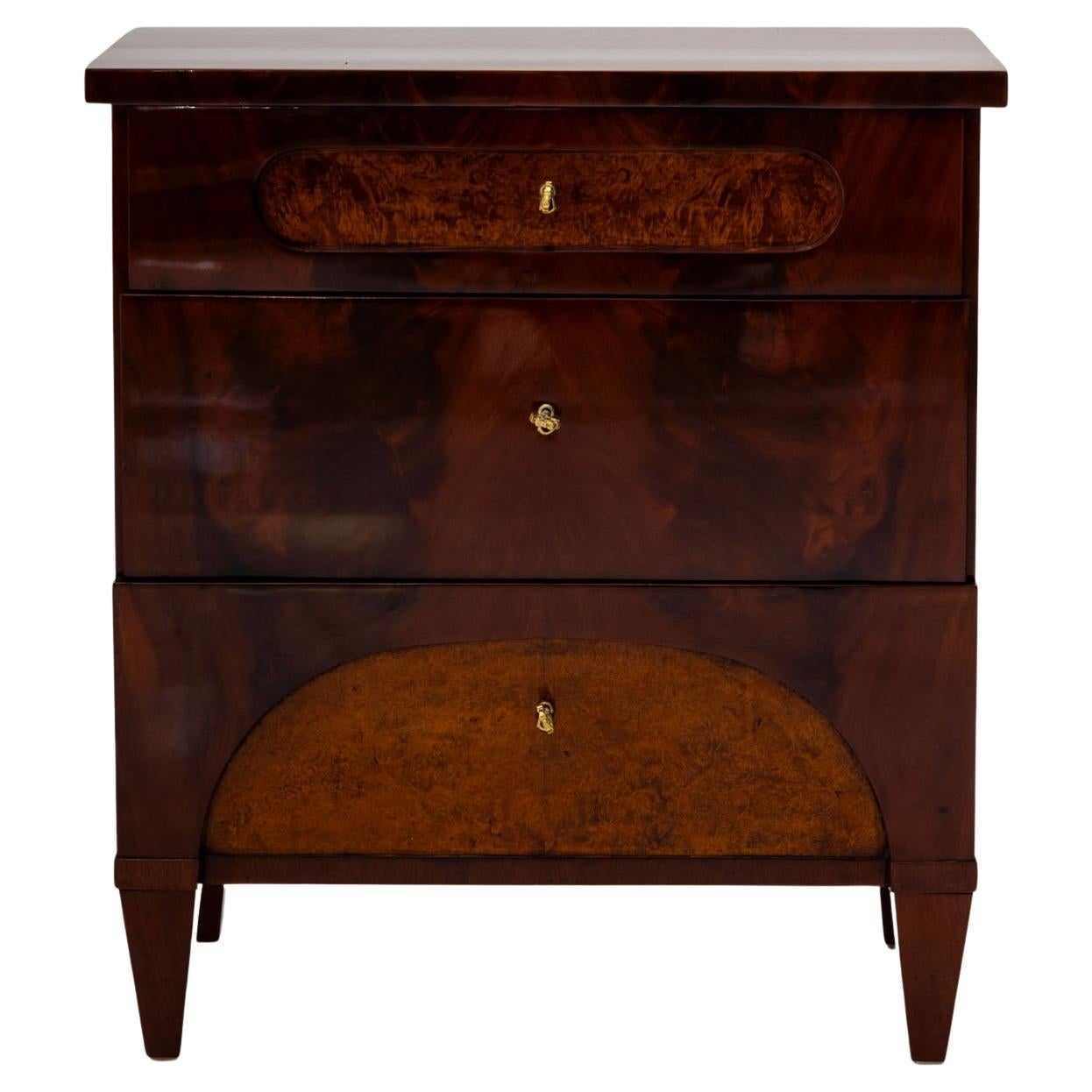 Classica cassettiera Biedermeier a tre cassetti proveniente dalla Germania settentrionale, realizzata intorno al 1830. Il design è caratterizzato da una geometria pulita e da un sorprendente contrasto tra il corpo in mogano e gli accenti in radica