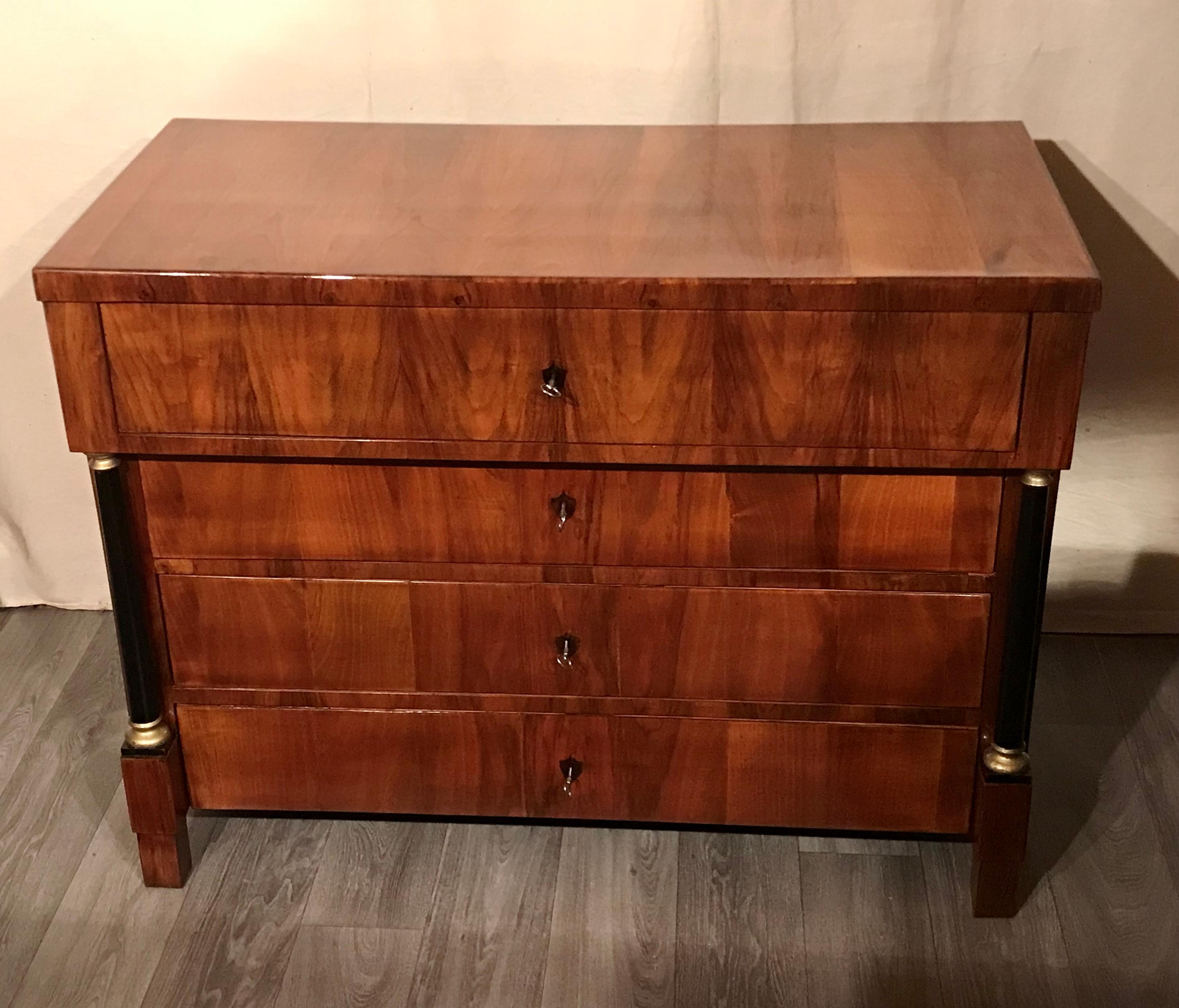 This elegant original Biedermeier chest of drawers dates back to around 1820. It was made in southern Germany. The four drawer baker chest has a beautiful walnut veneer. A writing compartment is hiding behind the slightly protruding upper drawer.
