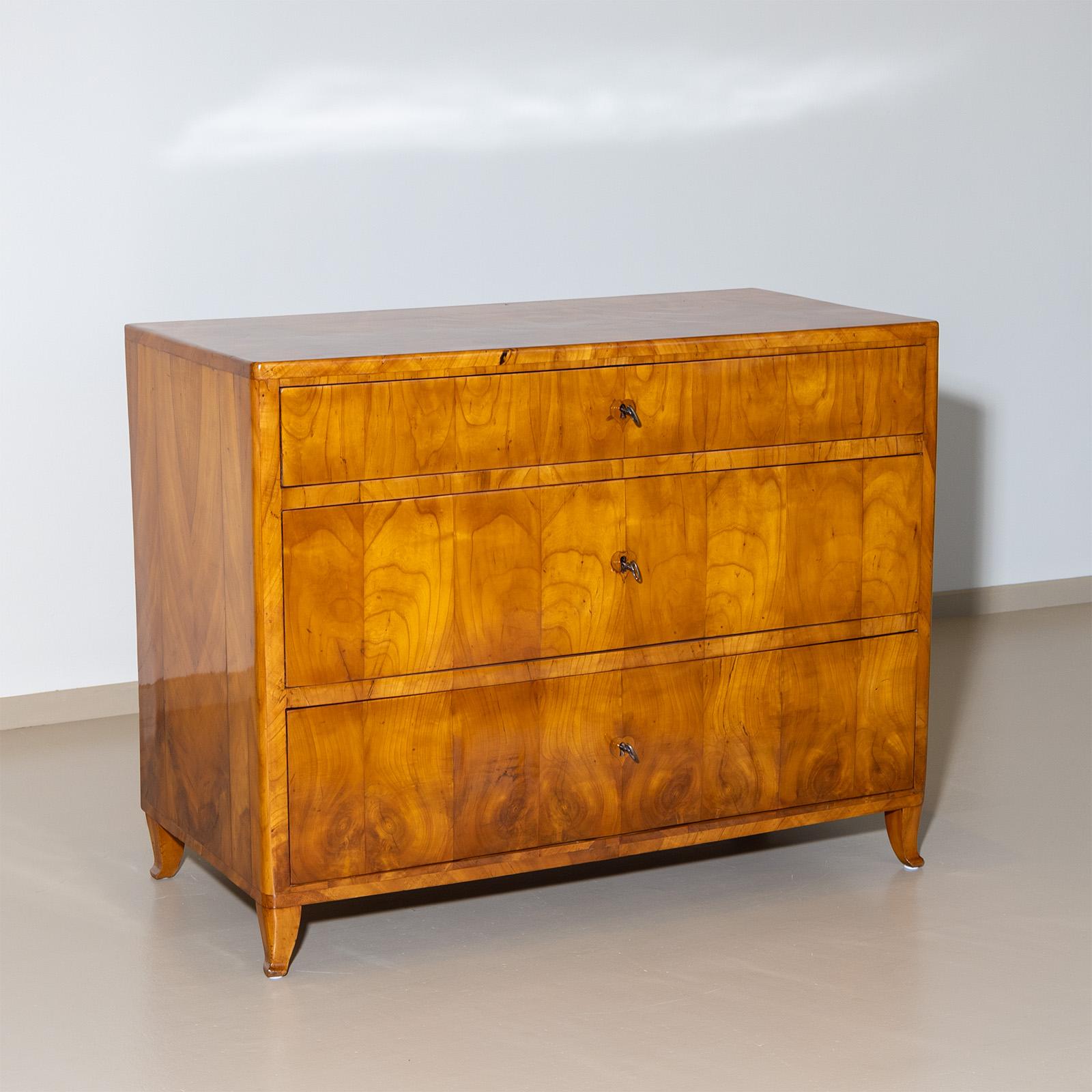 Diese exquisite Kommode aus dem Biedermeier besticht durch ihr wunderschönes Nussbaumfurnier mit einer sorgfältig restaurierten und handpolierten Oberfläche. Das Stück zeichnet sich durch sein schönes symmetrisches Furnierbild aus, das jedem Raum