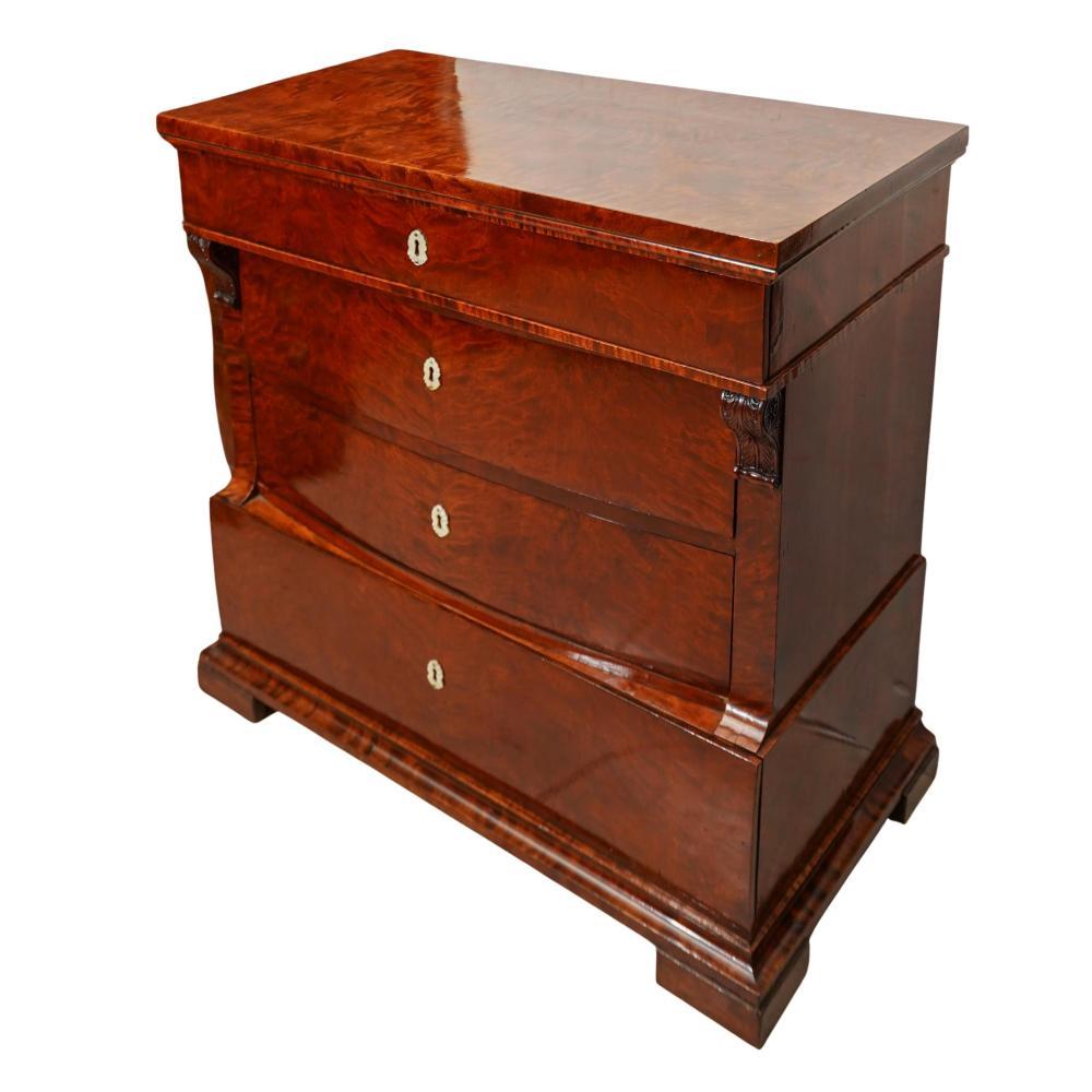 Cassettiera Biedermeier in noce e madreperla realizzata in impiallacciatura di noce con scure in madreperla. La cassapanca presenta un piano rettangolare sopra quattro cassetti graduati, ognuno dei quali mostra la simmetria pulita e l'ornamento