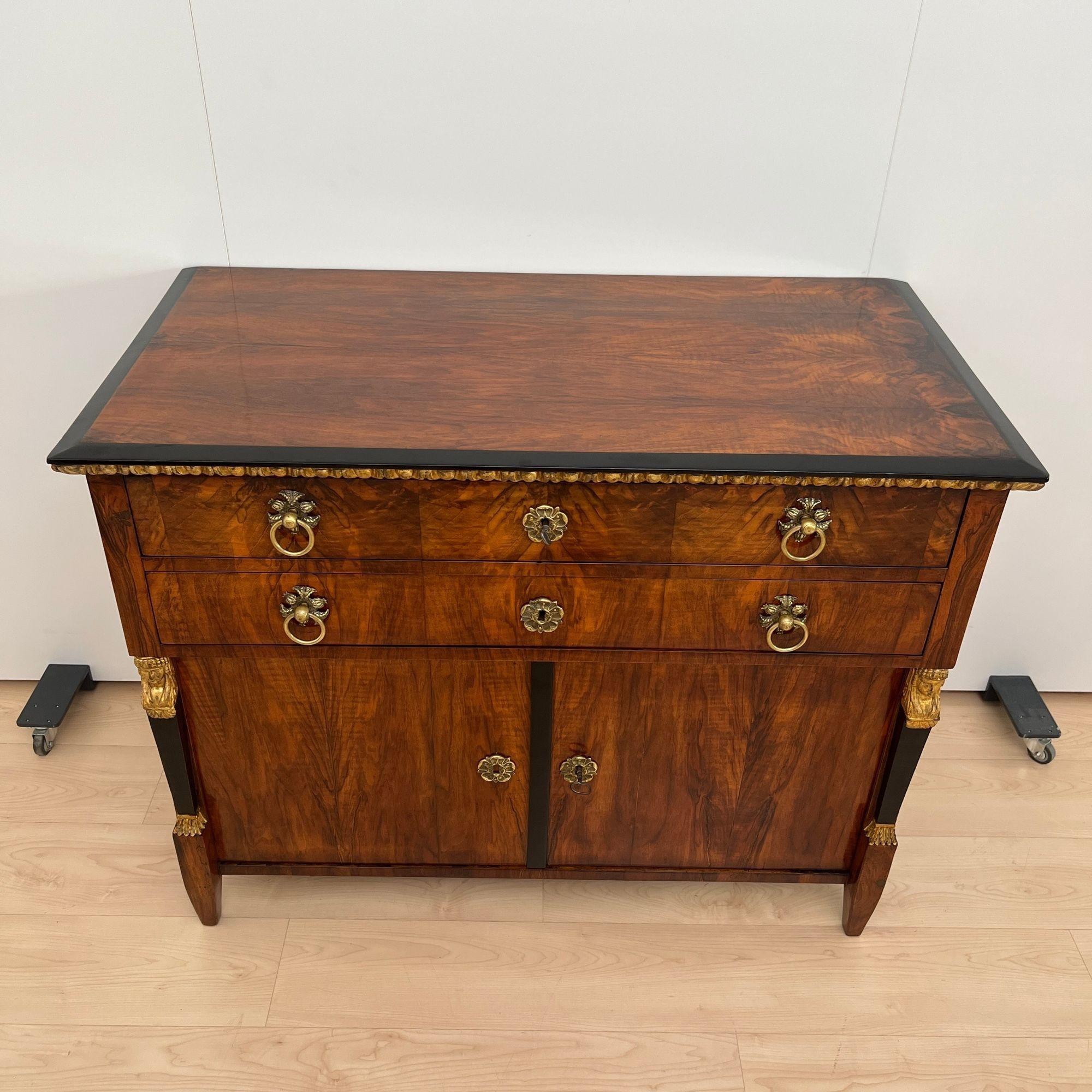 Extraordinary, early Biedermeier Chest, Commode or Half-cabinet from Austria around 1815.
Beautiful book-matched dark walnut veneer on softwood. Two doors at the bottom, counter-veneered in cherry wood on the inside. Inside an interior made later